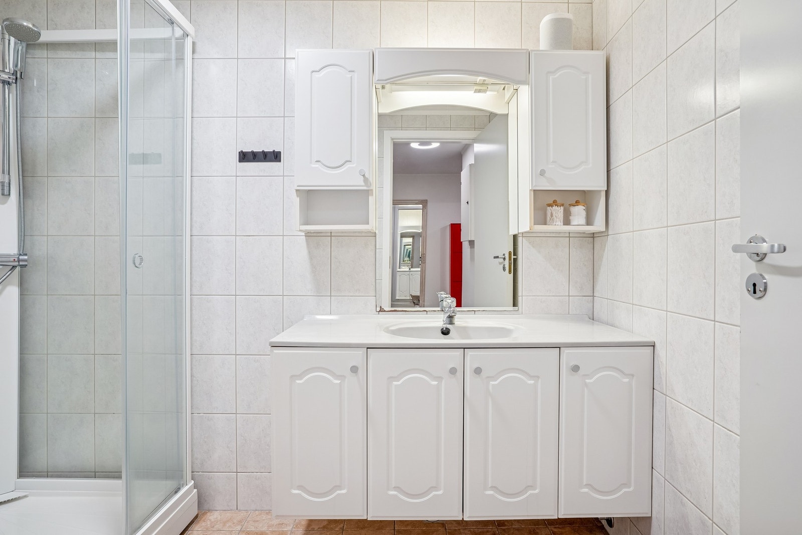 Badet har innredning med vegghengt skap, dusjkabinett, toalett og vaskemaskin Galleribilde