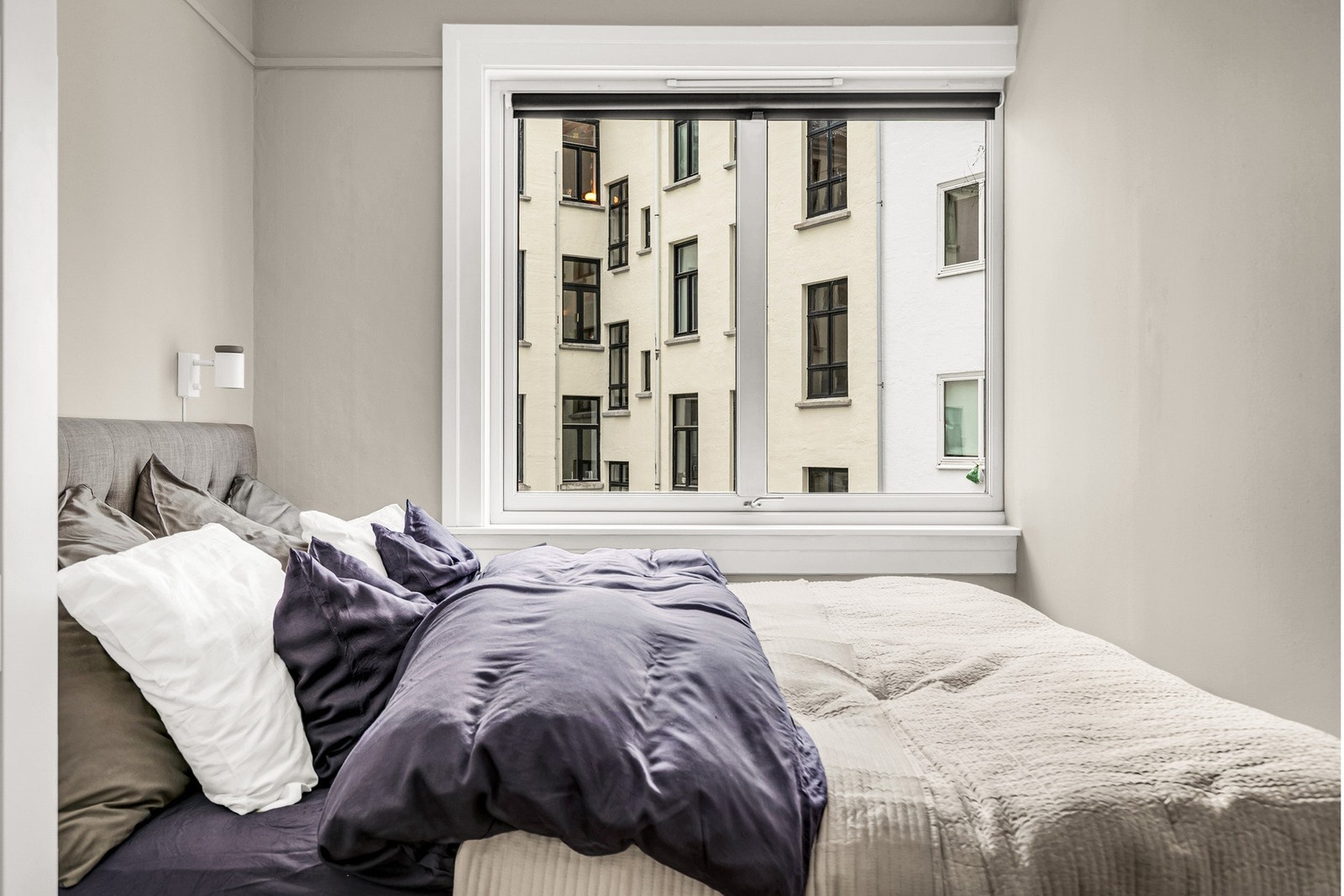 Lyst og rolig soverom med stort vindu mot bakgård, som gir godt lysinnslipp og en stille atmosfære. Galleribilde