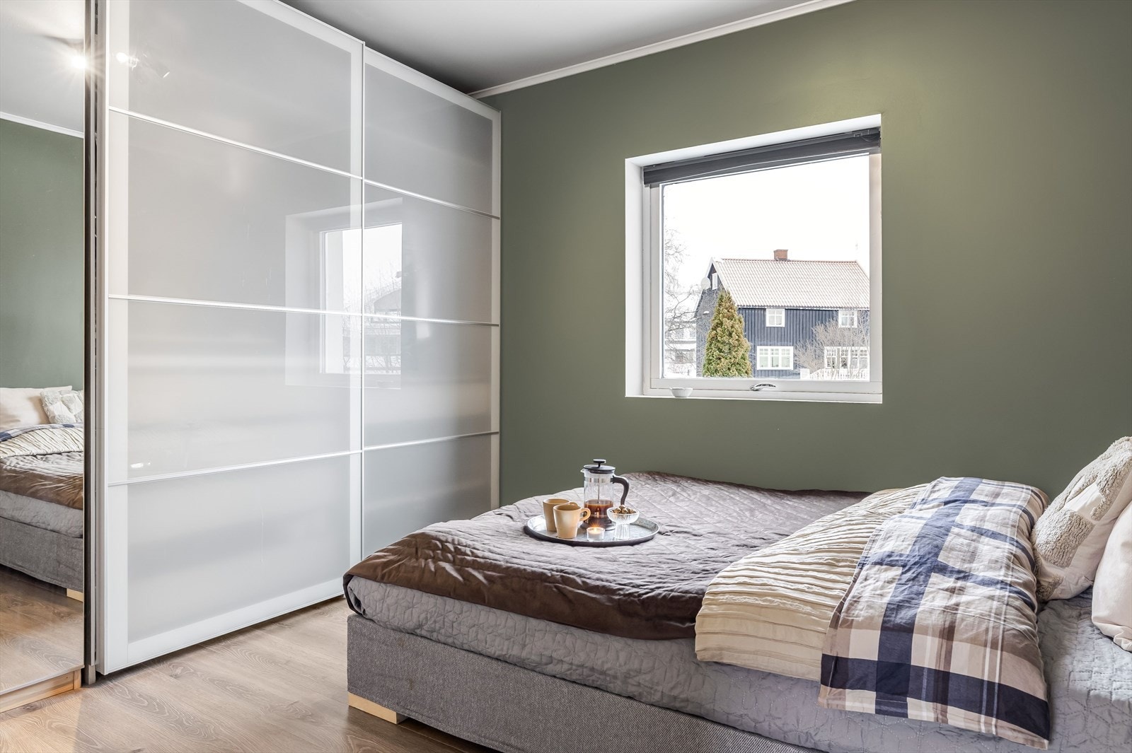 Rommet er malt i en delikat grønntone og har det samme lyse gulvet som i leiligheten for øvrig. Galleribilde