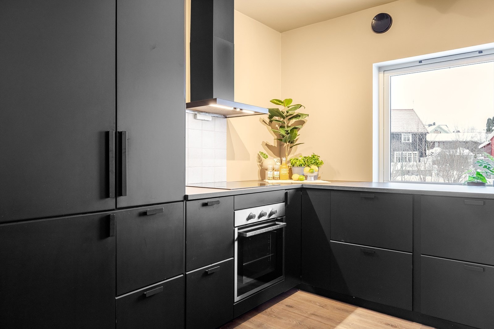 Pent og moderne kjøkken med innredning fra IKEA fra 2021. Det har integrerte hvitevarer som stekeovn, platetopp, kjøleskap med fryser og oppvaskmaskin. Galleribilde