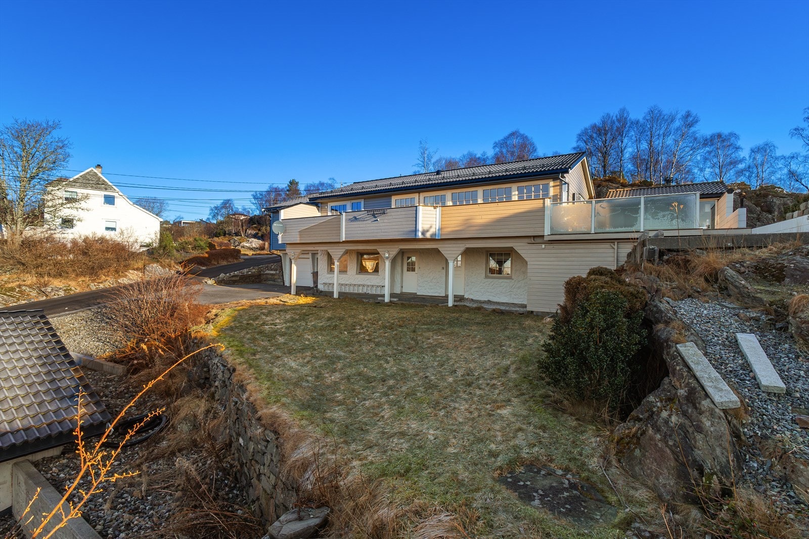 Hagen er ellers opparbeidet med plenområder med prydbusker på begge sider av boligen. Galleribilde