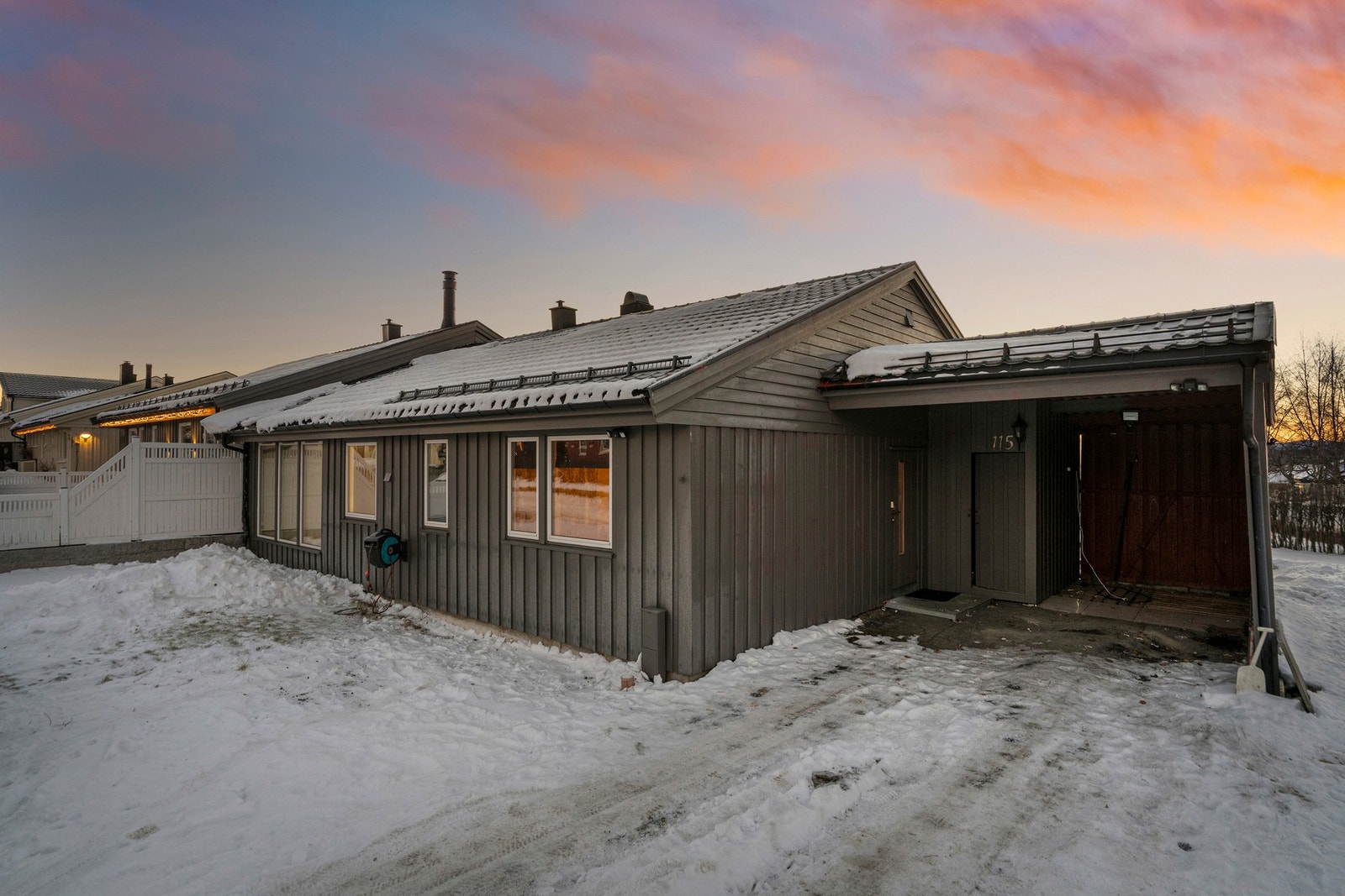 Vestvendt hage på framsiden med carport og praktisk utvendig bod, samt oppstillingsplass til flere biler. Galleribilde