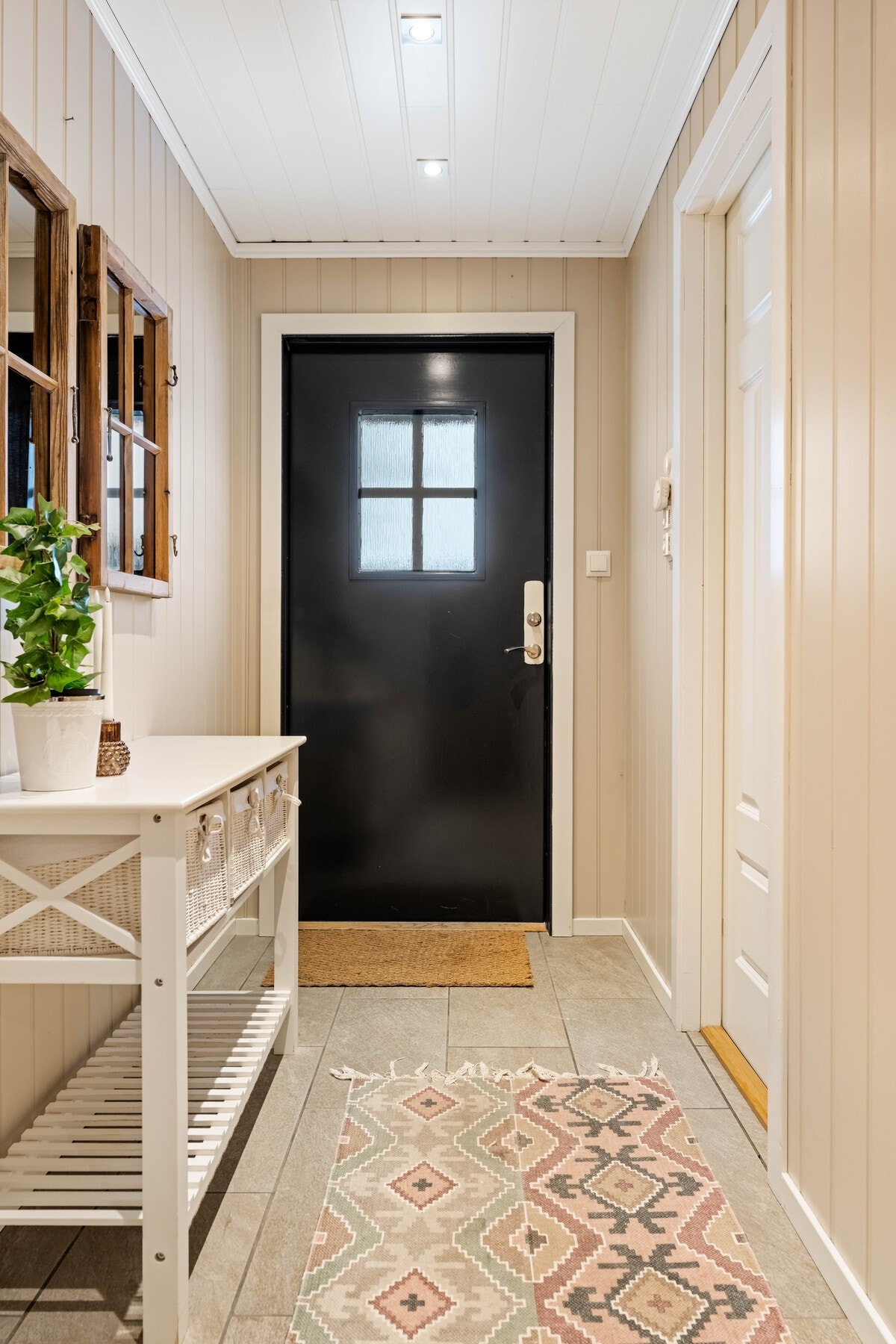 Innbydende entré med flislagt gulv og malt panel på veggene. Fra entréen er det adkomst til bad samt øvrige oppholdsrom. Galleribilde