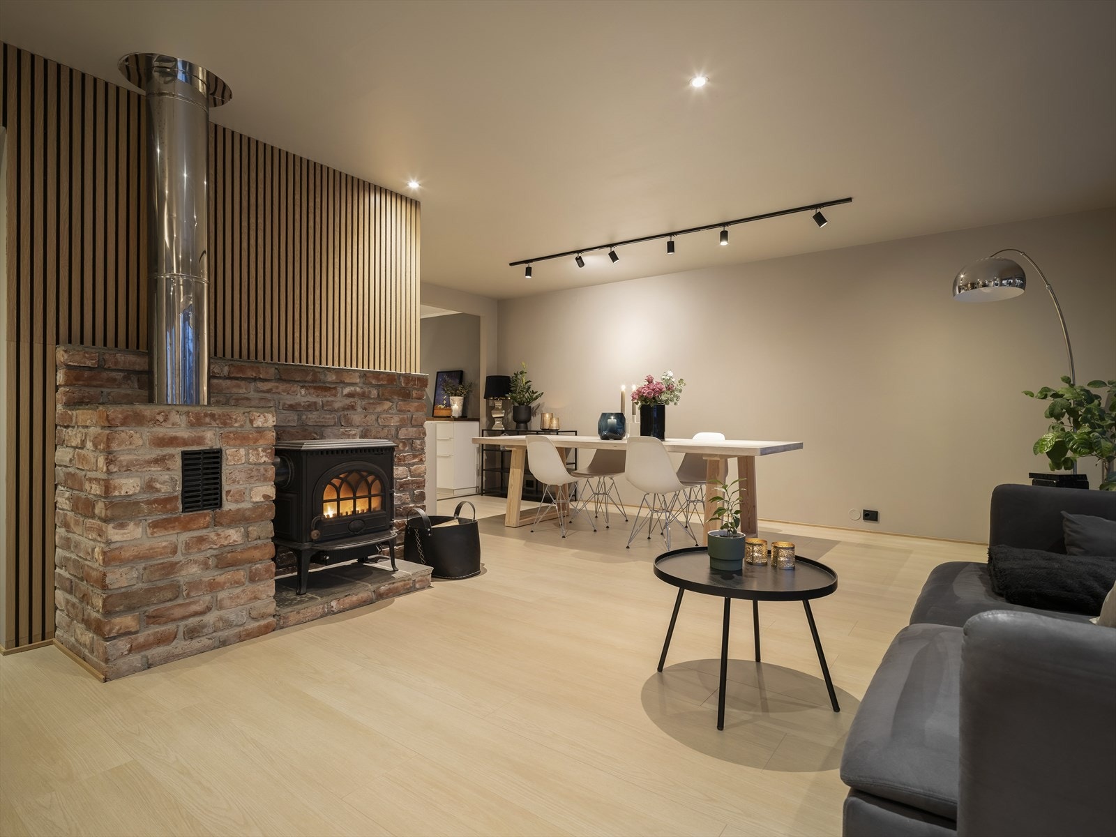 Den rustikke teglsteinspipen med vedovn skaper en lun atmosfære. Galleribilde