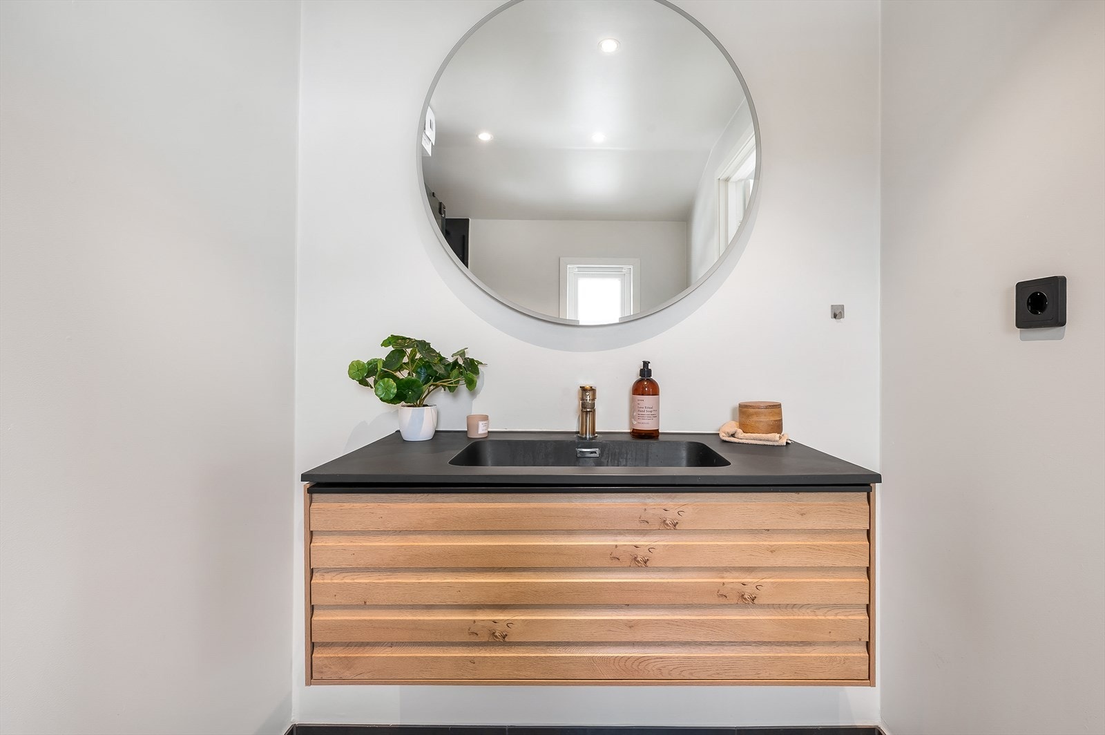 Baderom med vegghengt innredning i tre. Det er oppbevaringmuligheter i skuffer Galleribilde