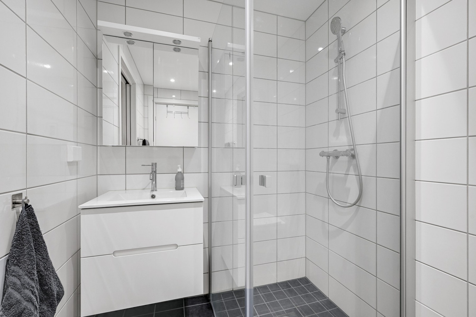 Badet er innredet med dusjhjørne med praktiske glassdører Galleribilde