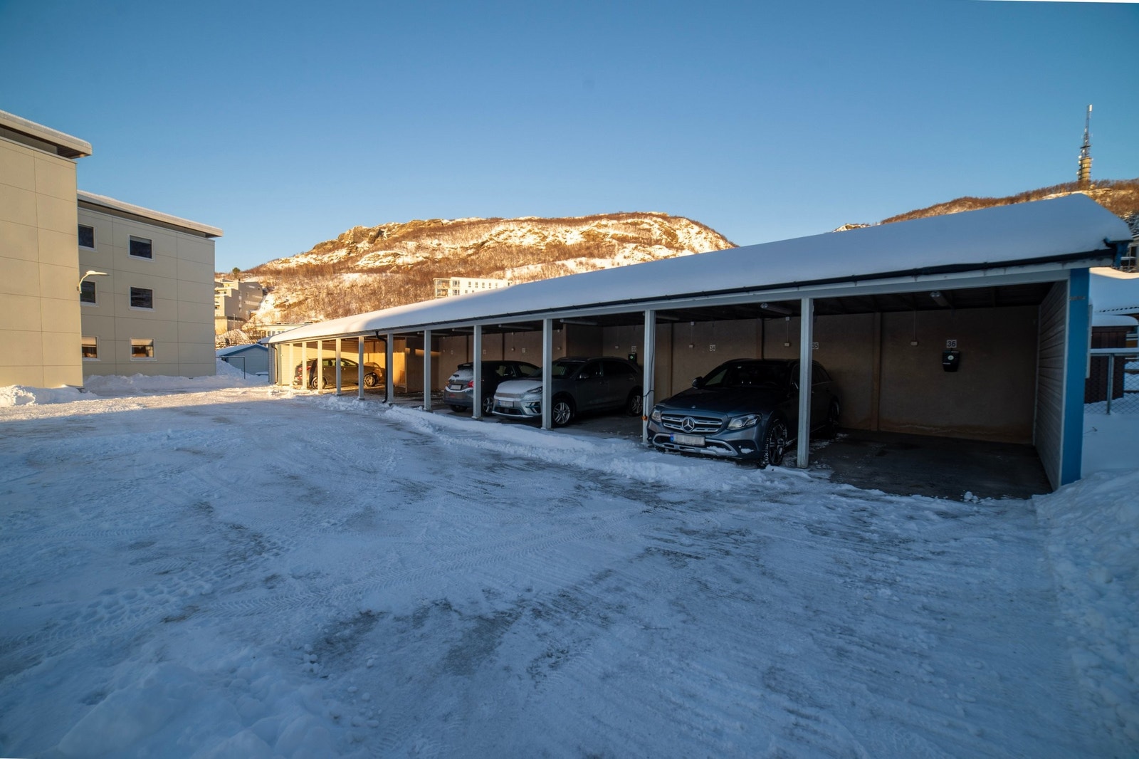 Carport ytterst i rekka med fastmontert elbillader fra 2023. Galleribilde