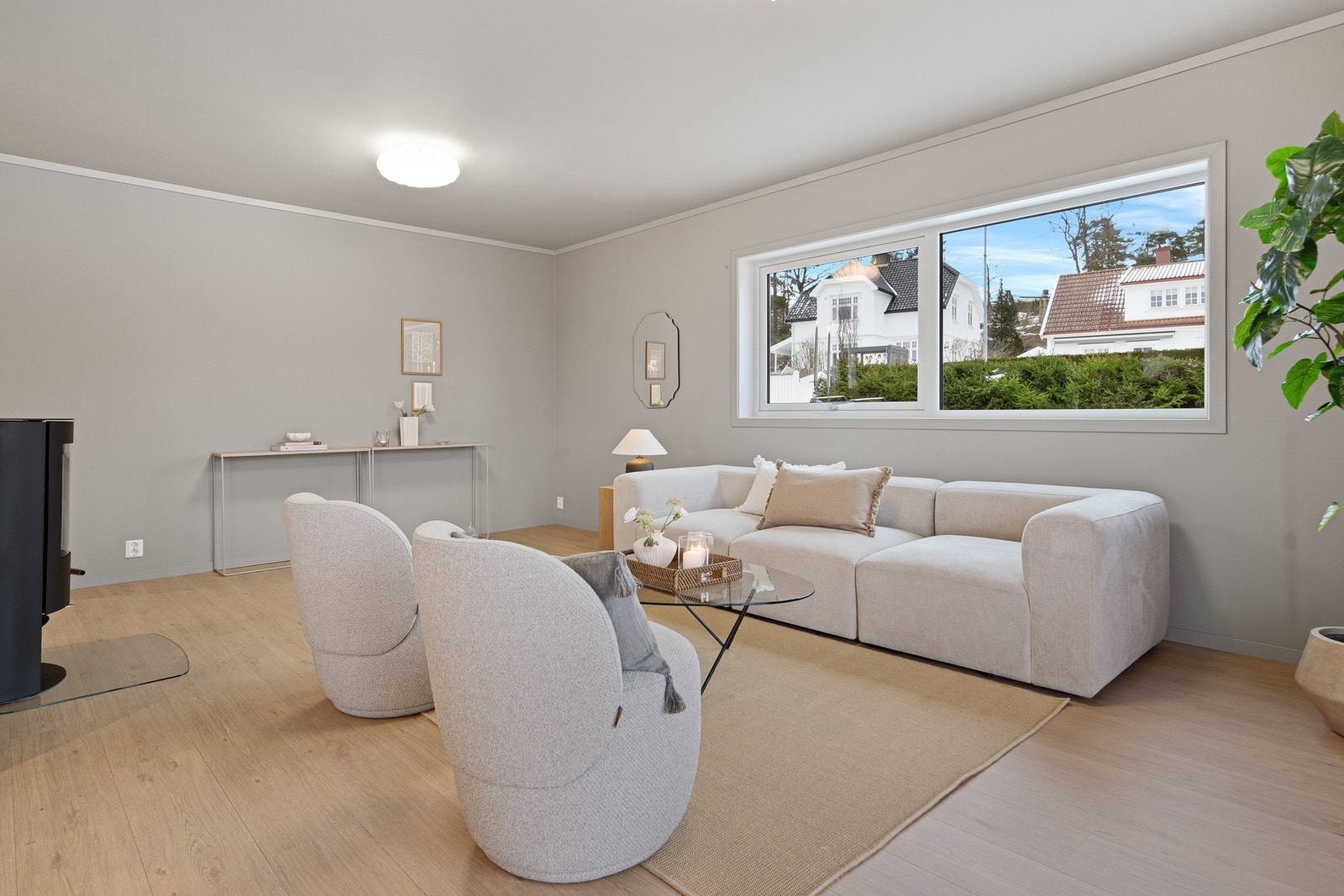 Store vindusflater slipper inn rikelig med naturlig lys og gir rommet en behagelig og lett stemning. Stuen har god plass til både sofagruppe og sitteplasser, og kan enkelt tilpasses ulike møbleringsløsninger. De dempede tonene, valgt av stylister, gir rom Galleribilde