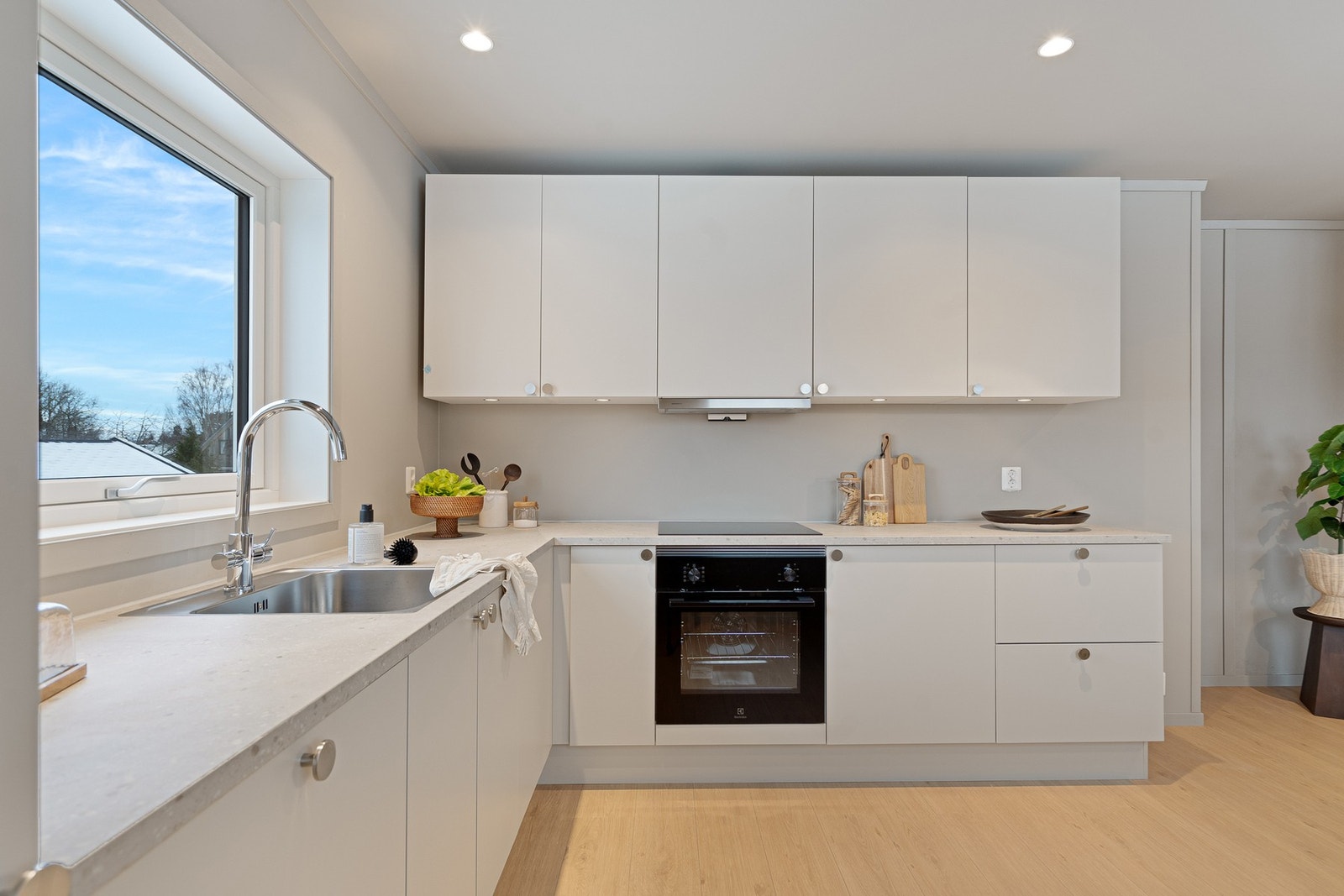 Kjøkkenet er stilrent og moderne, med glatte fronter, integrerte hvitevarer og god benkeplass. Løsningen er både praktisk og estetisk, og kjøkkenet blir et naturlig samlingspunkt i boligen. Galleribilde