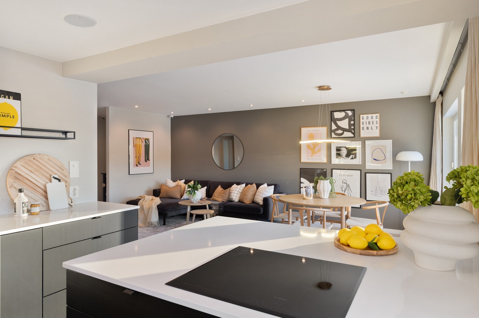 Pen og lys benkeplate i stein gir en myk kontrast til sort kjøkkeninnredning Galleribilde