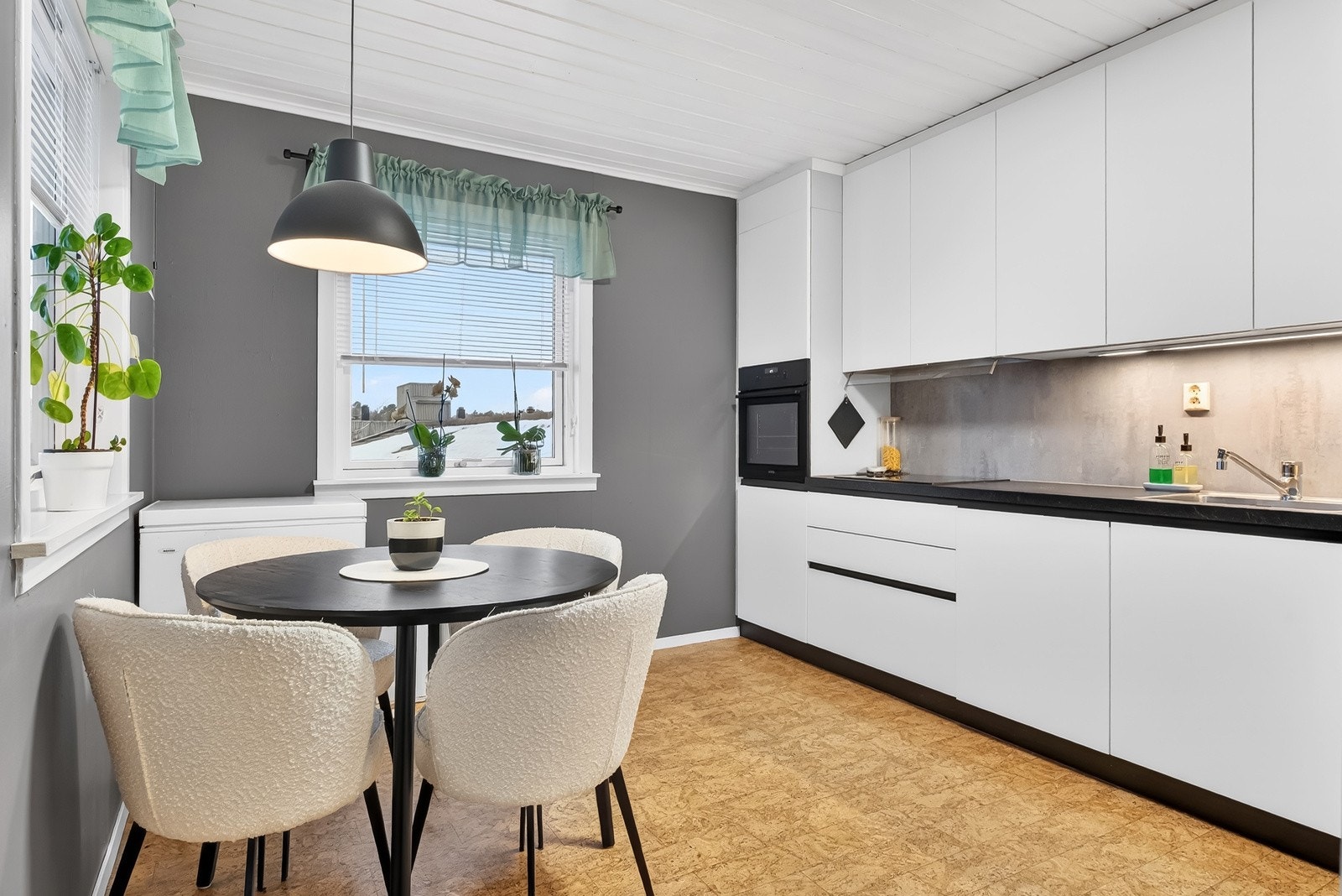 Lyst og romslig kjøkken med plass til frokostbord ved vinduene. Galleribilde