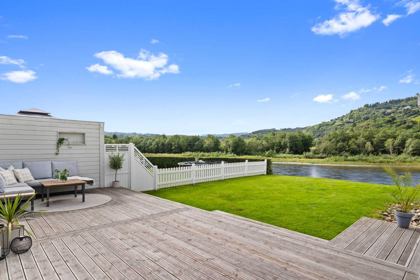 Koselig hage med plen og utsikt over Gaula. Galleribilde