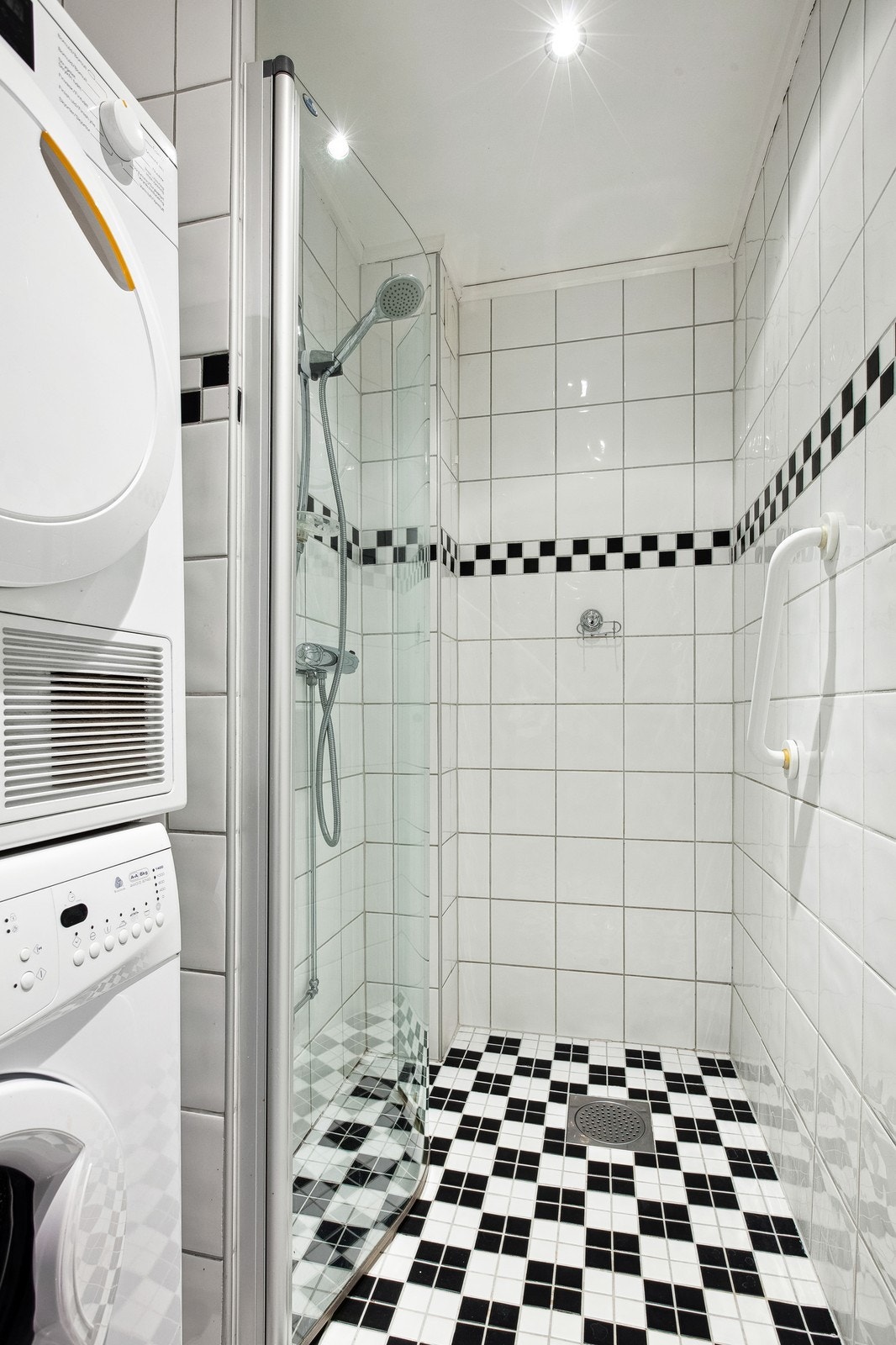 Pent, flislagt bad med opplegg for vaskemaskin og tørketrommel. Galleribilde