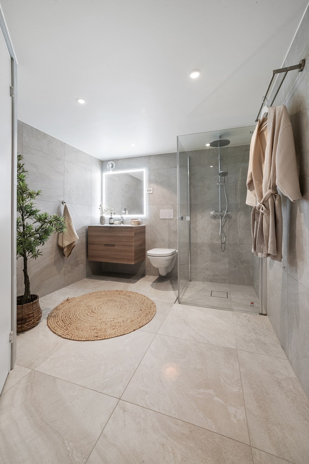 Romslig bad fra 2025 med flislagte overflater og downlights i himling. Galleribilde