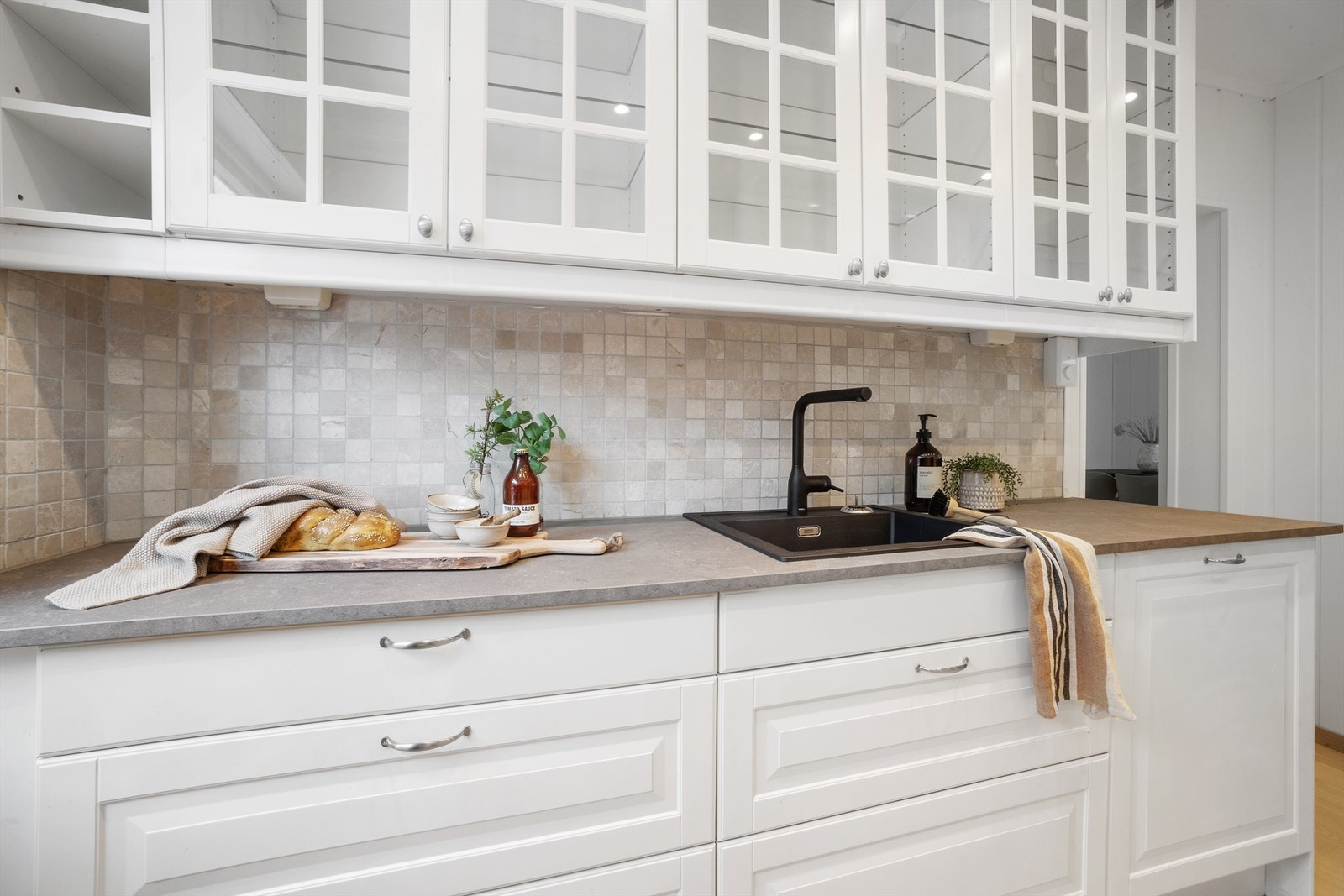 Lyse mosaikkfliser mellom kjøkkenbenk og overskap. Galleribilde