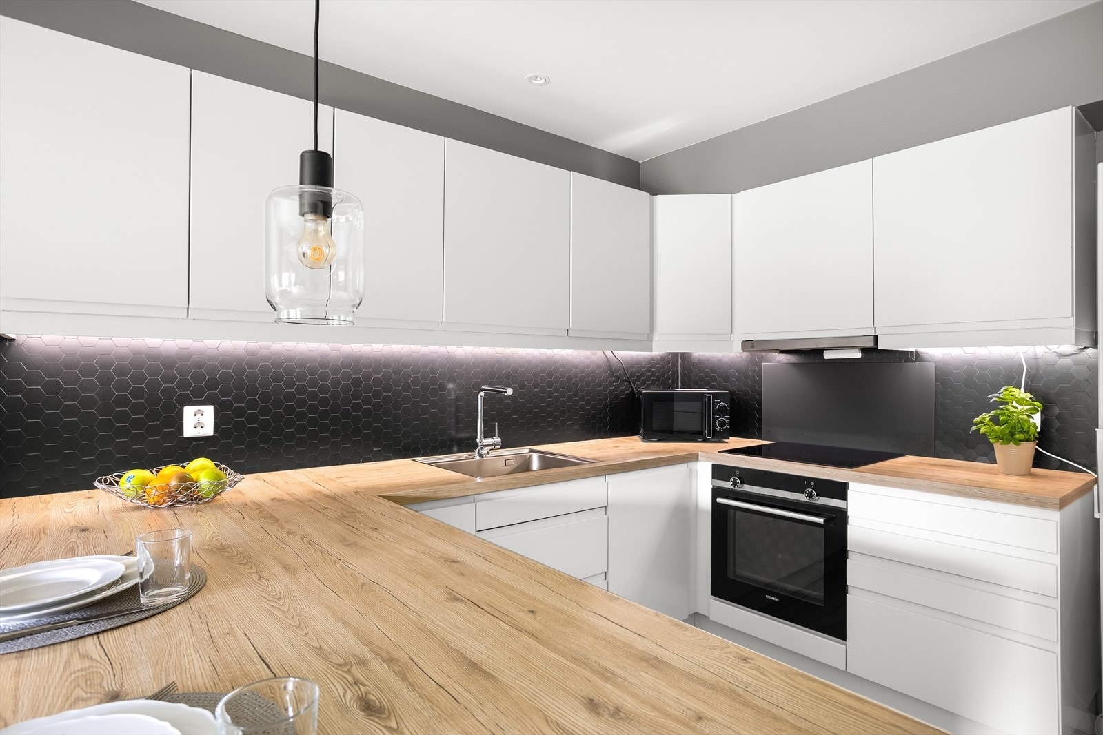 Kjøkkenet har integrerte hvitevarer som steketopp, komfyr og oppvaskmaskin. Galleribilde