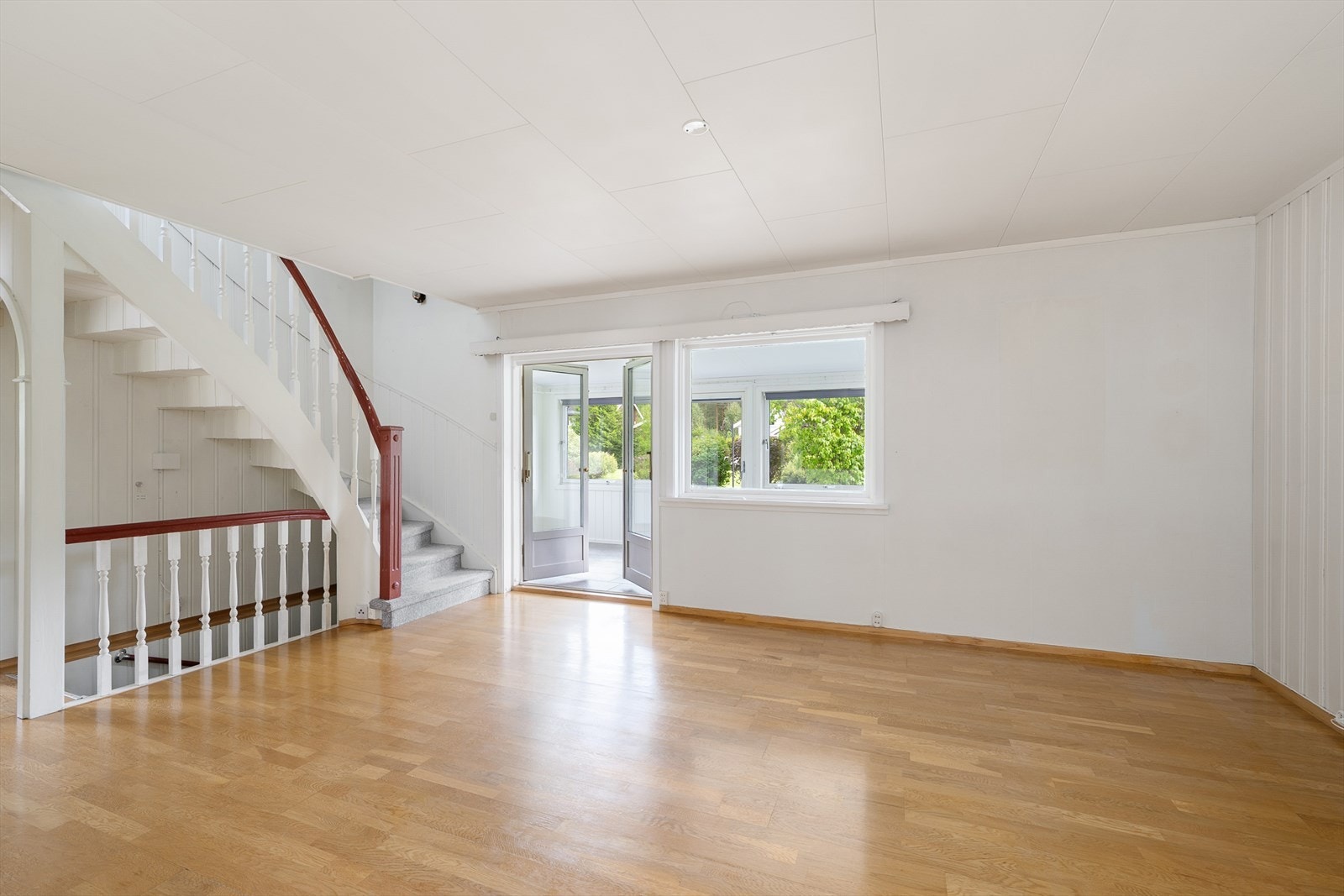 Velkommen inn - Et større stuerom med lyse overflater Galleribilde