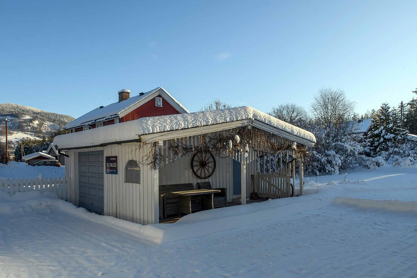 Tilhørende garasje med overbygget platting som har plass til utemøbler Galleribilde