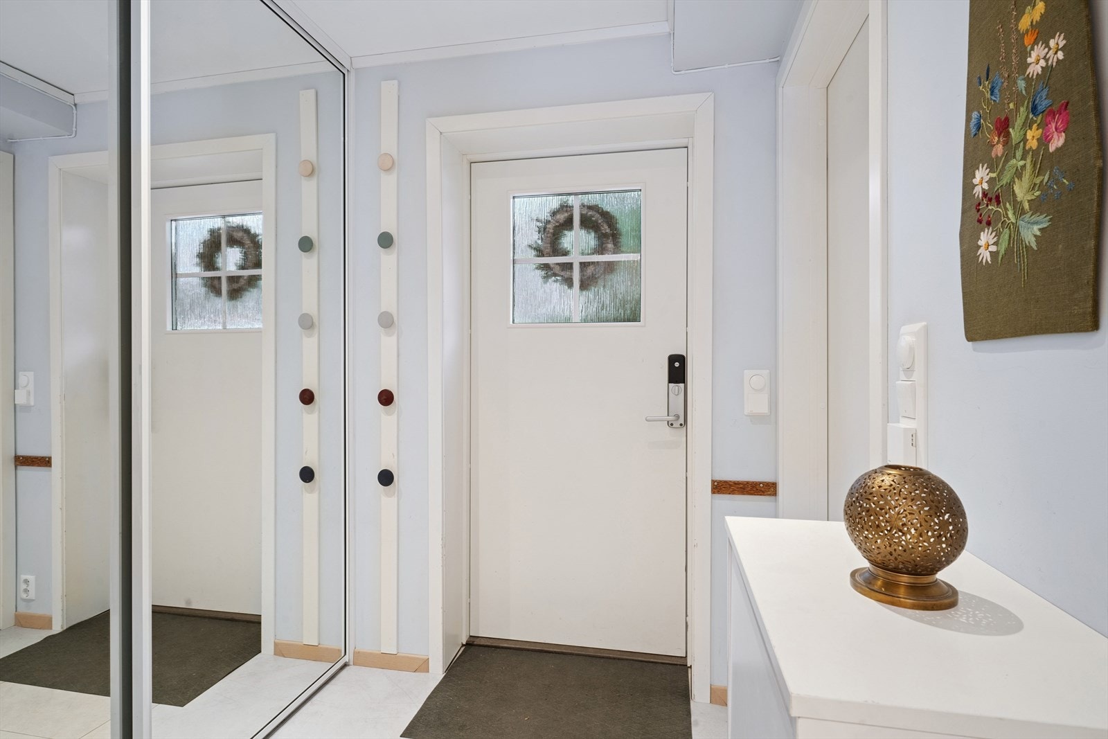 Velkommen inn. Entréen gir deg plass til å henge i fra deg ytterklærne dine i skyvedørsgarderoben her inne. Galleribilde