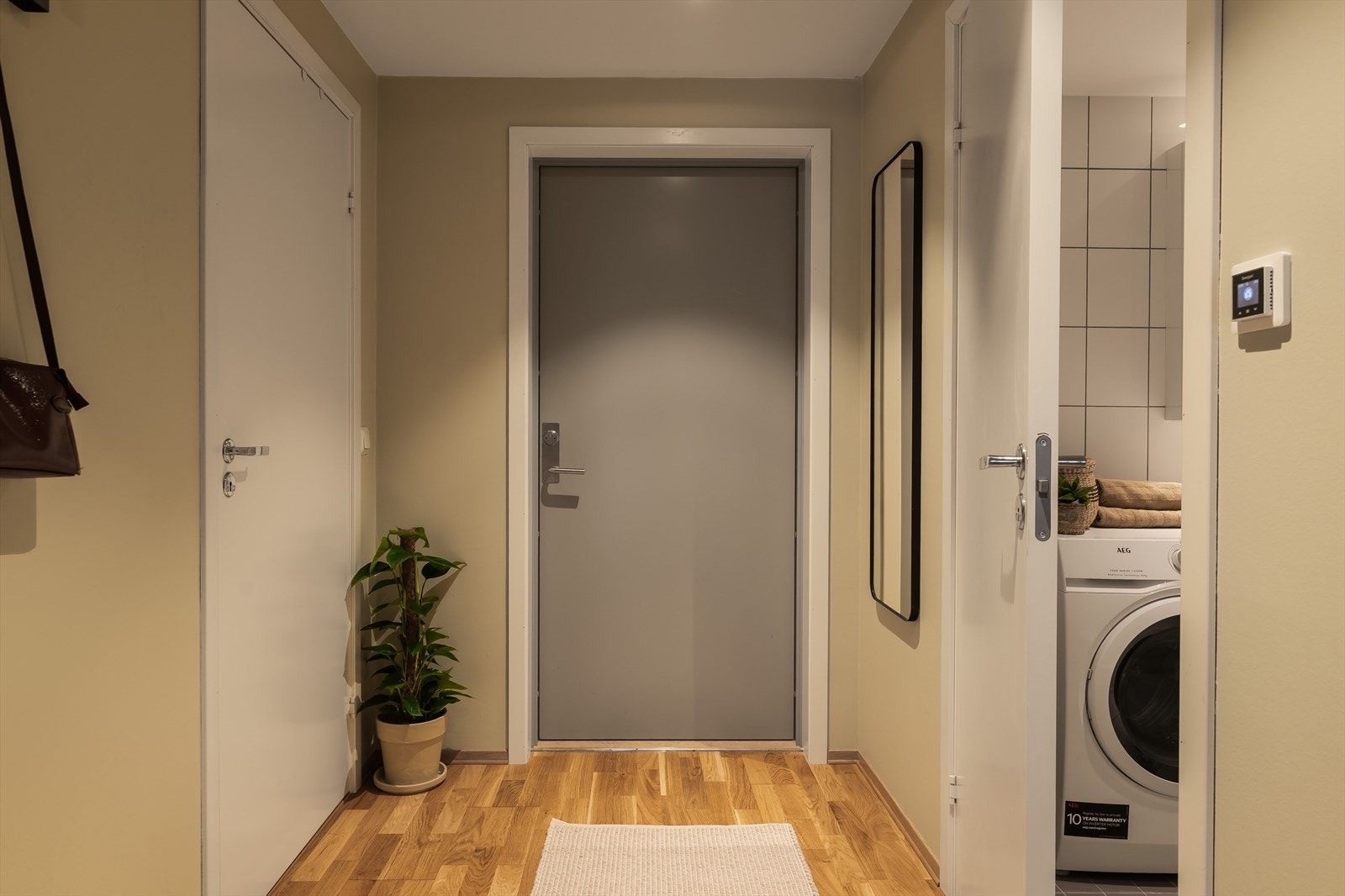 Entréen er romslig og har plass til ulike oppbevaringsløsninger. Her har man adkomst til leilighetens bad og bod. Galleribilde