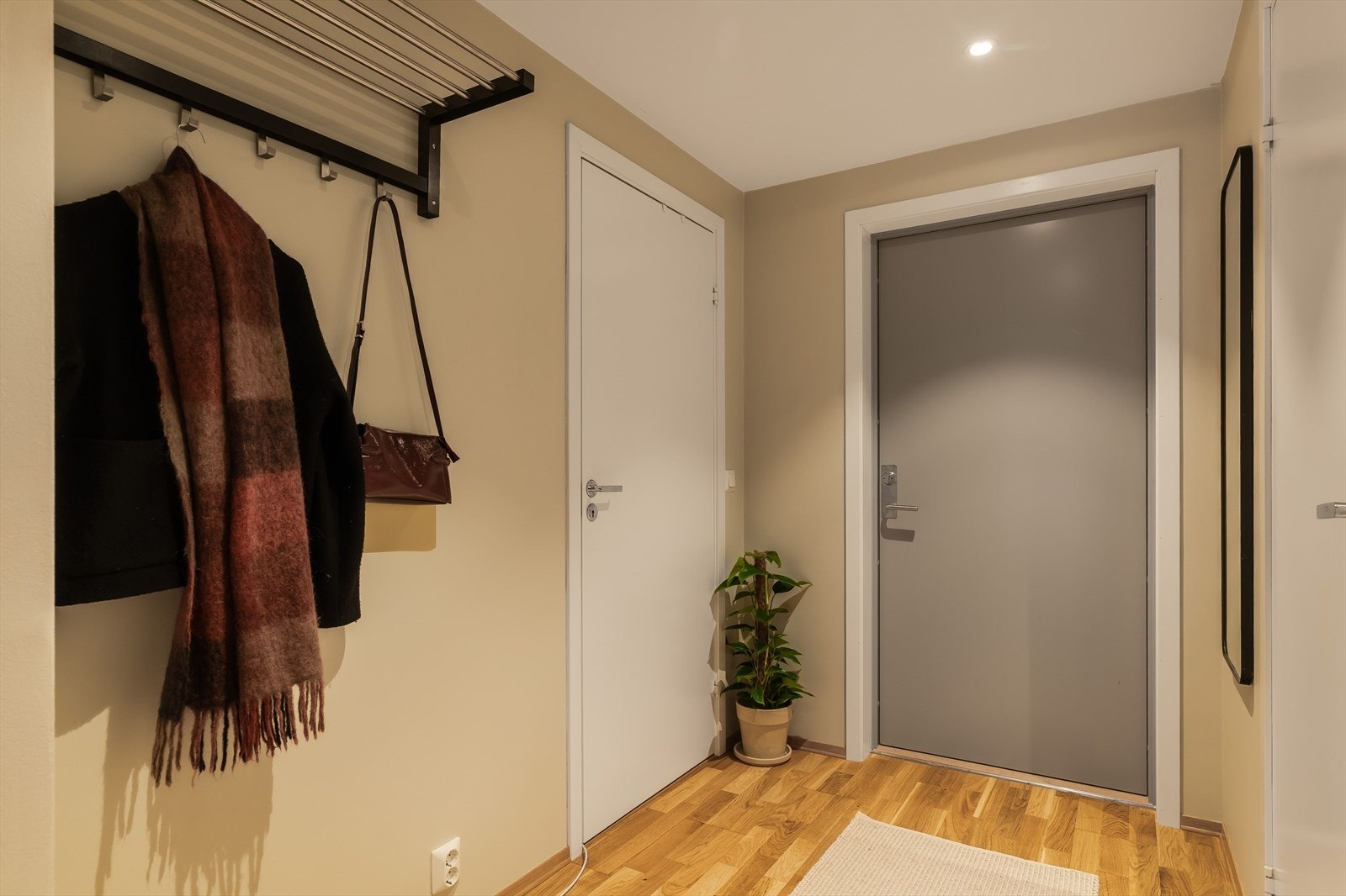 Entréen har lyse overflater og parkettgulv, og gir en god første opplevelse av boligen med naturlig adkomst videre til stue og kjøkken. Galleribilde