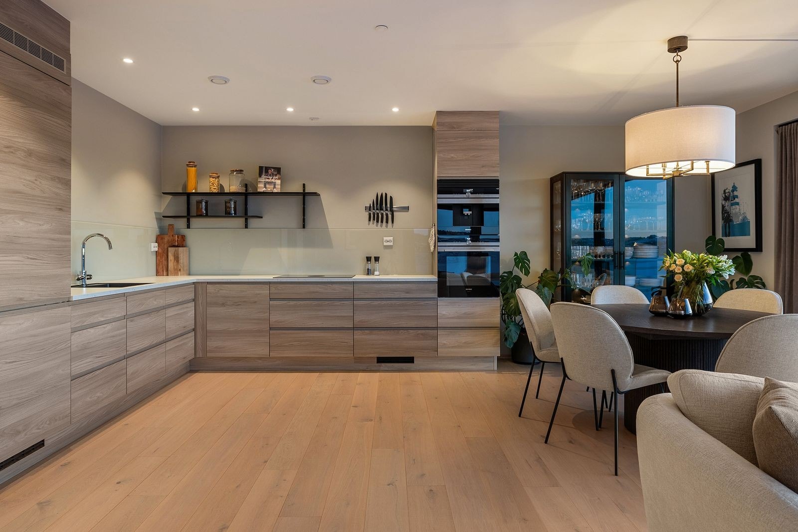 Stilsikker kjøkkeninnredning fra Strai med integrerte kjøl/frys, oppvaskmaskin, Bora koketopp, stekeovn og kaffemaskin Galleribilde