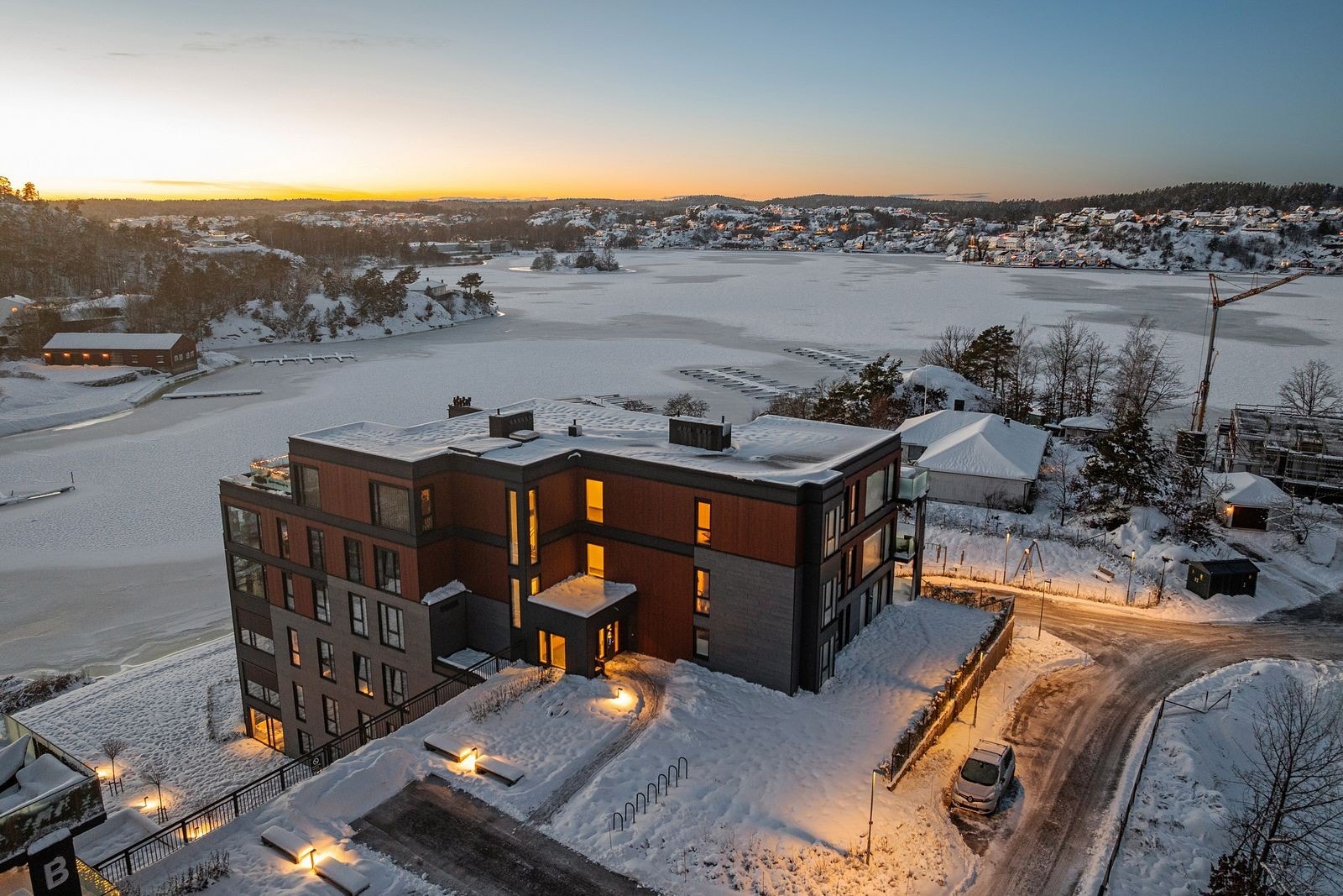 Oversiktsbilde over boligblokken med sjøen i bakgrunnen Galleribilde