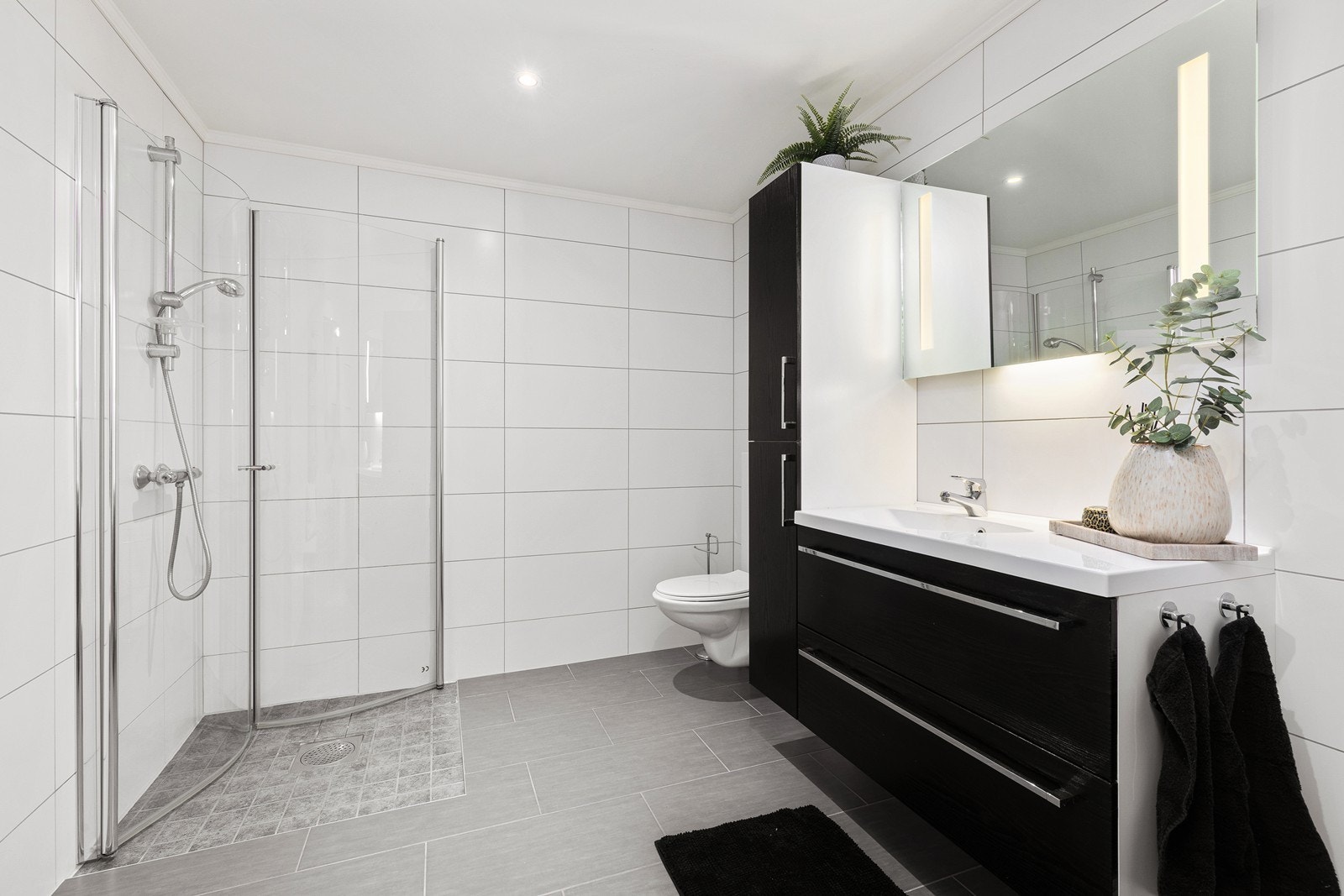 Badet er stilrent og flislagt med både gulvvarme og downlights i taket for en behagelig atmosfære. Galleribilde