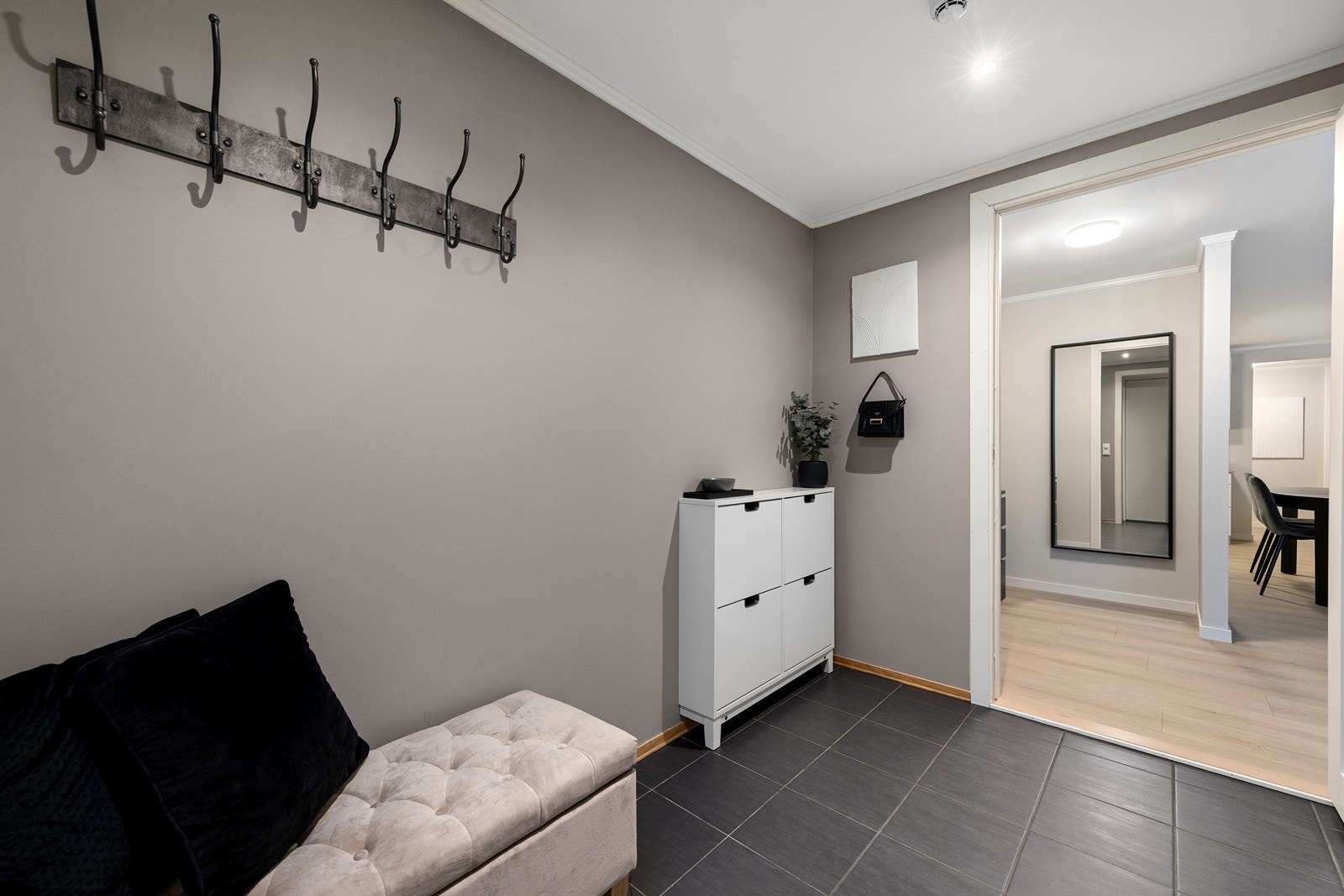 Den romslige, flislagte entréen gir gode muligheter oppheng og oppbevaring av yttertøy og sko. Galleribilde