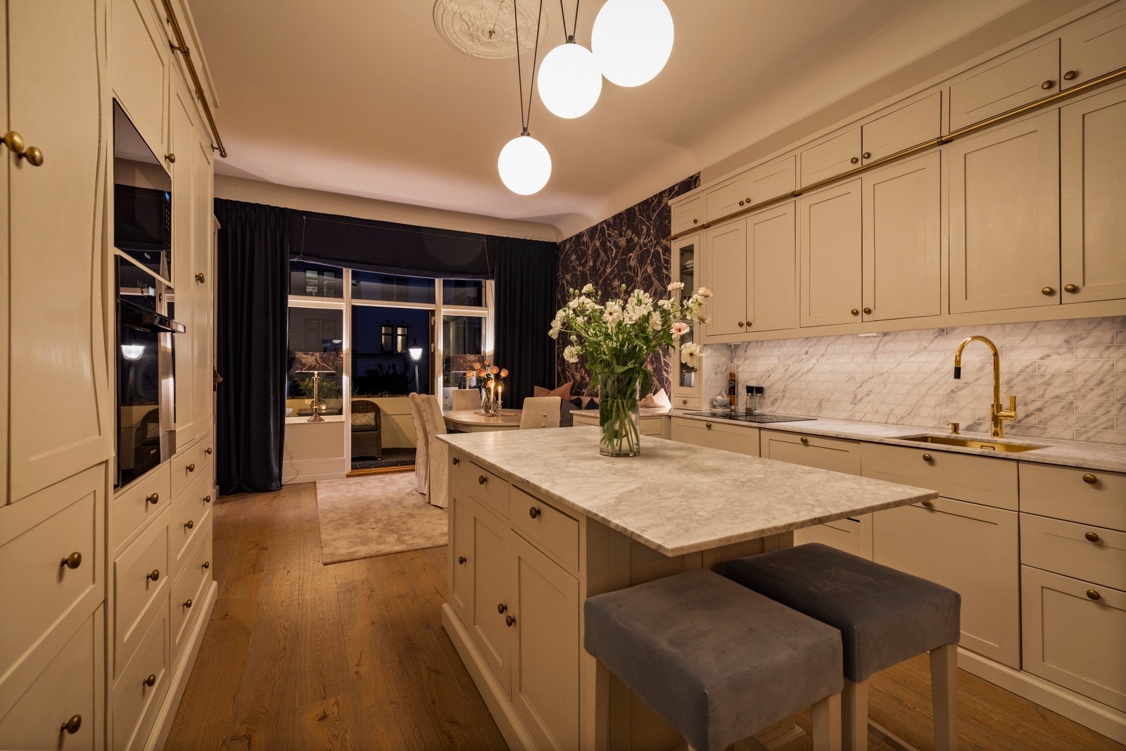 Når mørket senker seg, forvandles kjøkkenet til en elegant ramme for kvelden - med stemningsfull belysning og varm atmosfære. Galleribilde