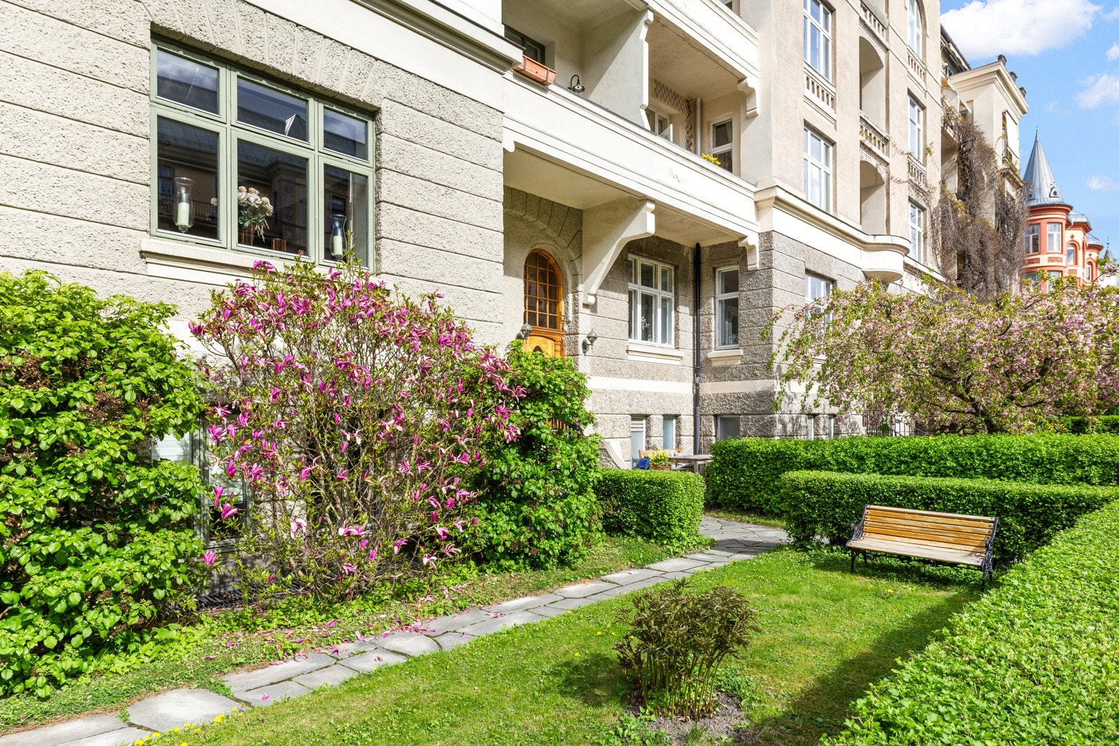 Solrik og frodig uteplass med grønne omgivelser - et rolig grøntrom midt i byen, perfekt for avslapning og hyggelige stunder på dagtid. Galleribilde