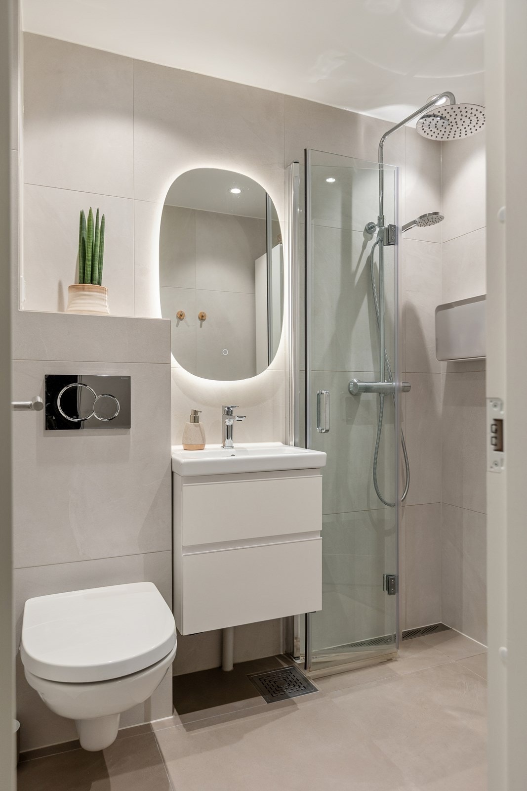 Lekkert baderom fra 2022. Badet er utstyrt med servant, vegghengt toalett og dusj, samt baderomsinnredning med skap med glatte fronter. Galleribilde