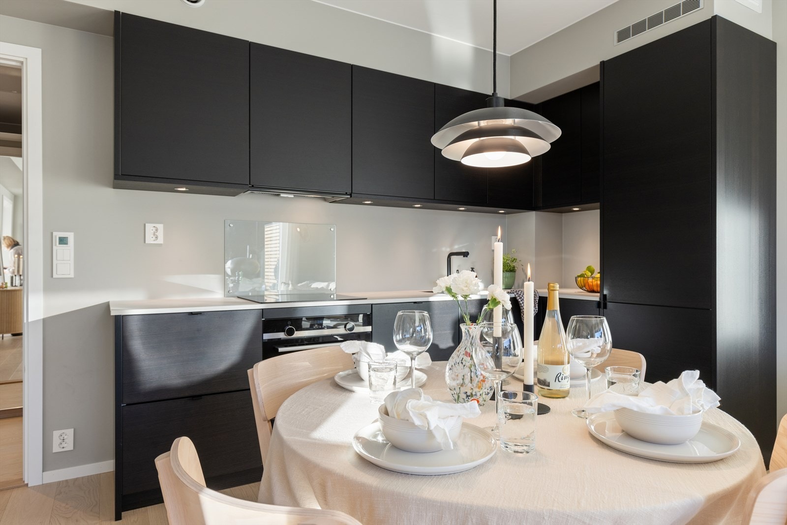 Kjøkkenet er stilrent med mørke, glatte fronter og har en naturlig plass for spisebord. Galleribilde