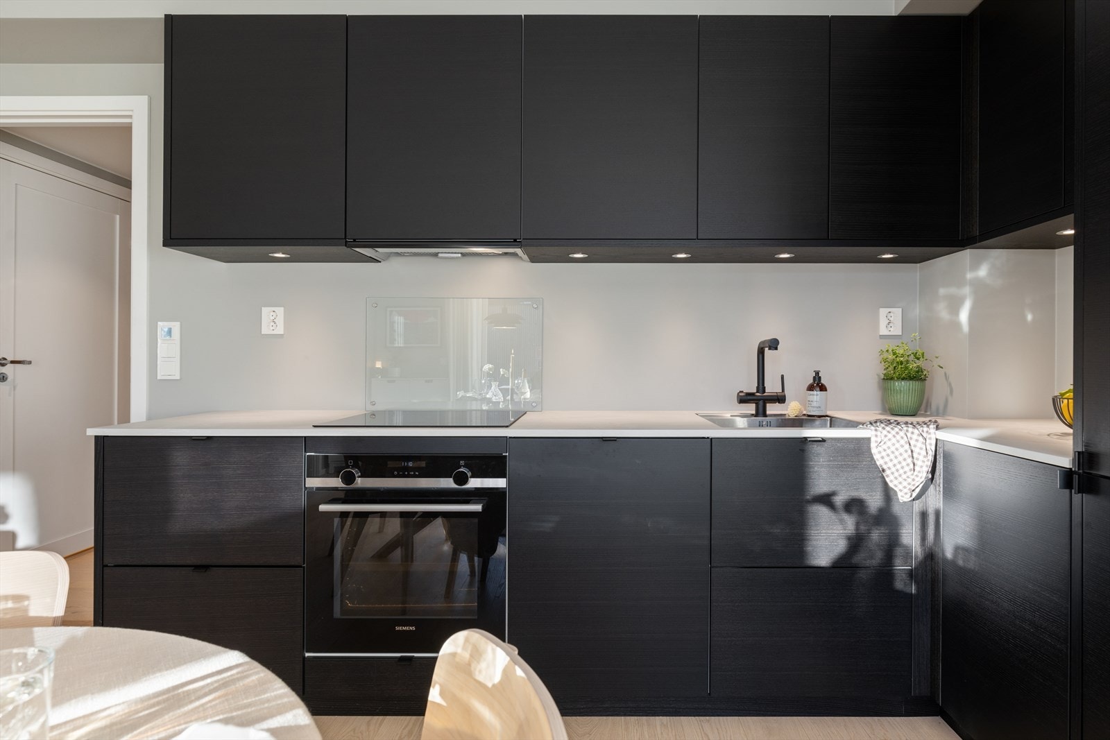 Kjøkkenet er utstyrt med integrerte hvitevarer fra Siemens, inkludert stekeovn og induksjonstopp. Galleribilde