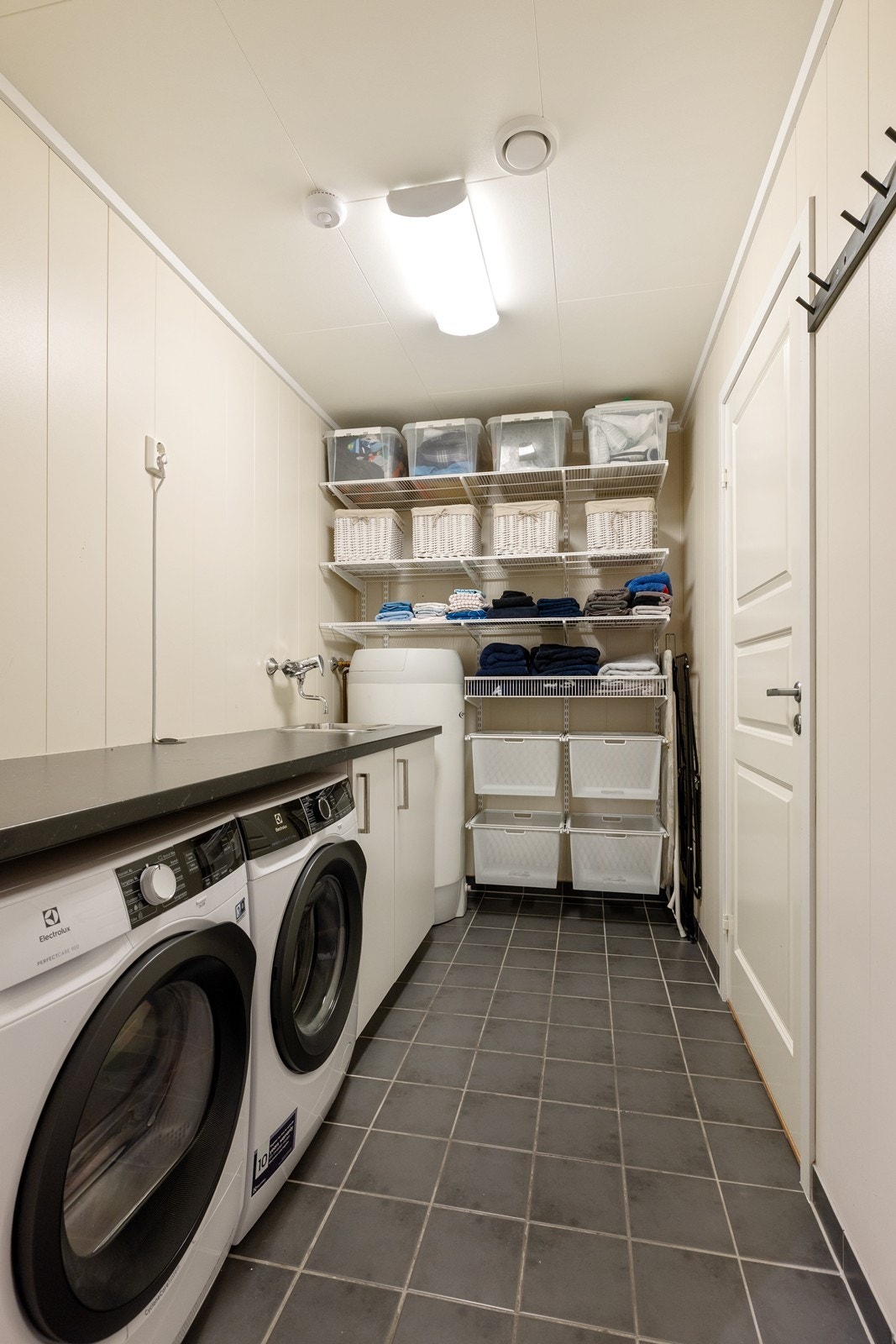 Vaskerommet er for øvrig innredet med benkeinnredning, skyllekum og opplegg for vaskemaskin og tørketrommel. Galleribilde