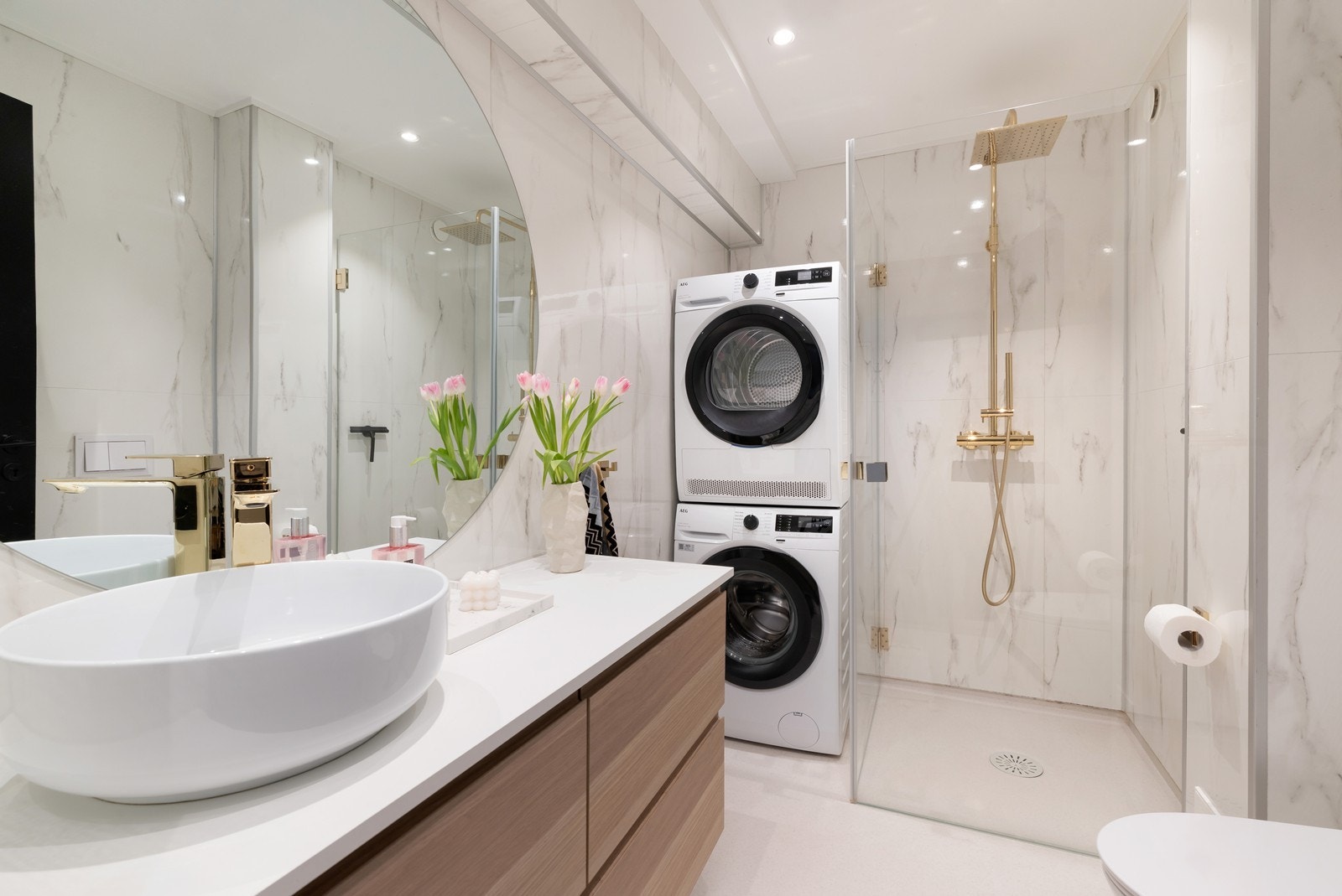 Delikat bad med dusjhjørne, servant, wc og opplegg av vaskemaskin og tørketrommel Galleribilde