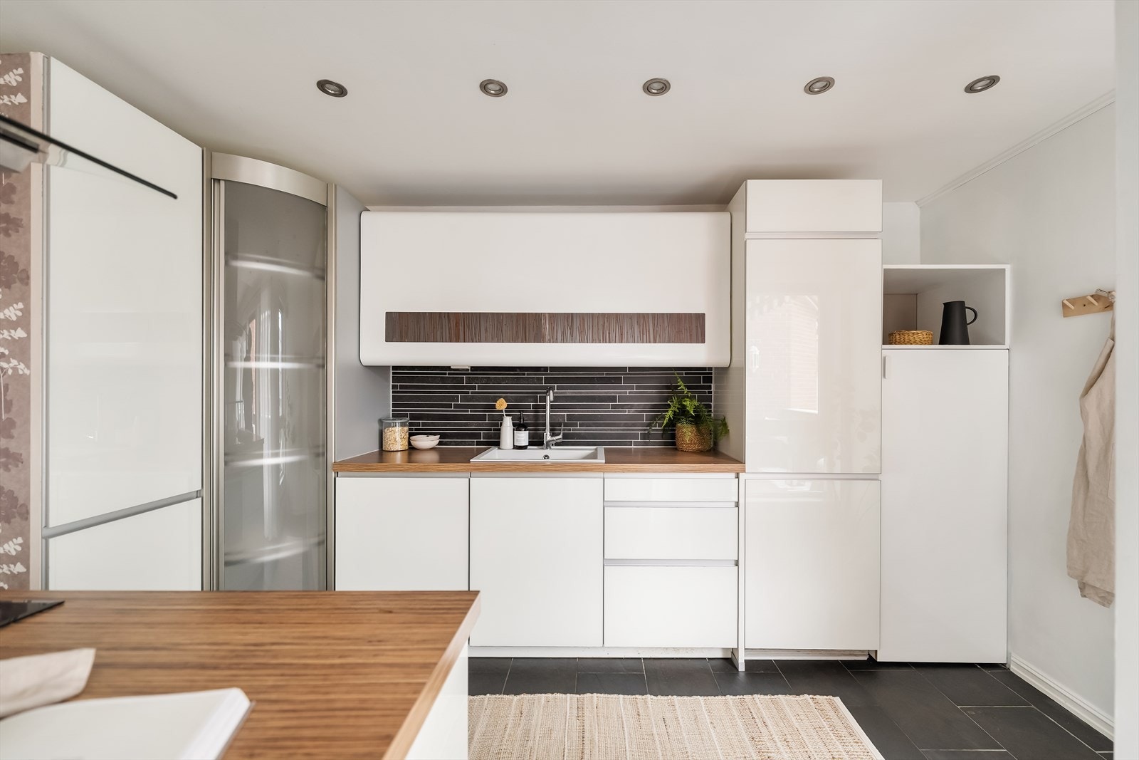 Kjøkkeninnredningen består av glatte fronter og laminert benkeplate gir et tidløst uttrykk. Det er utstyrt med kjøleskap, oppvaskmaskin, platetopp, stekeovn og ventilator med kullfilter. Galleribilde