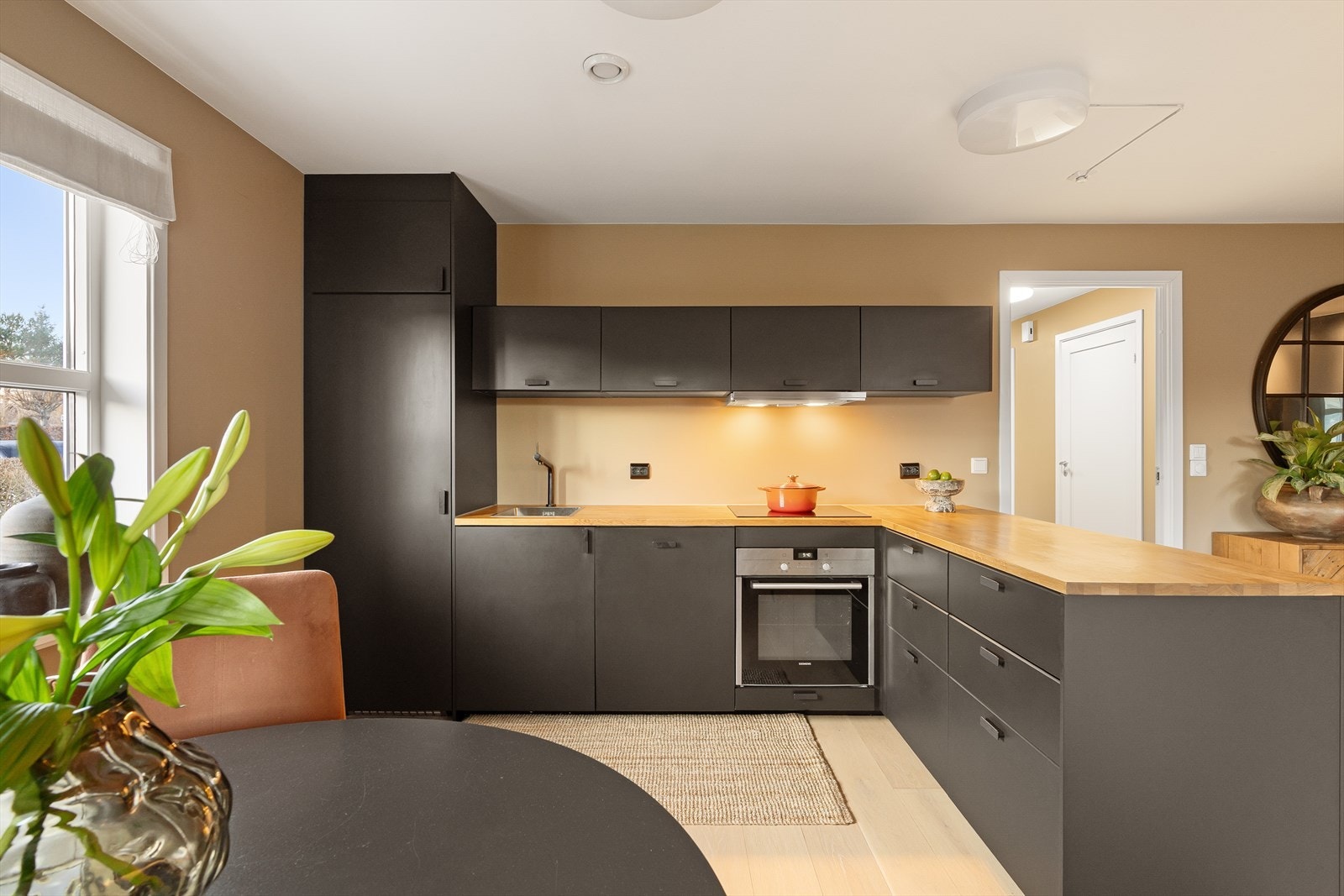 Lekkert kjøkken med god skap- og benkeplass, her er det mørke fronter og benkeplate i tre samt integrerte hvitevarer som oppvaskmaskin, stekeovn, platetopp og kjøleskap. Galleribilde