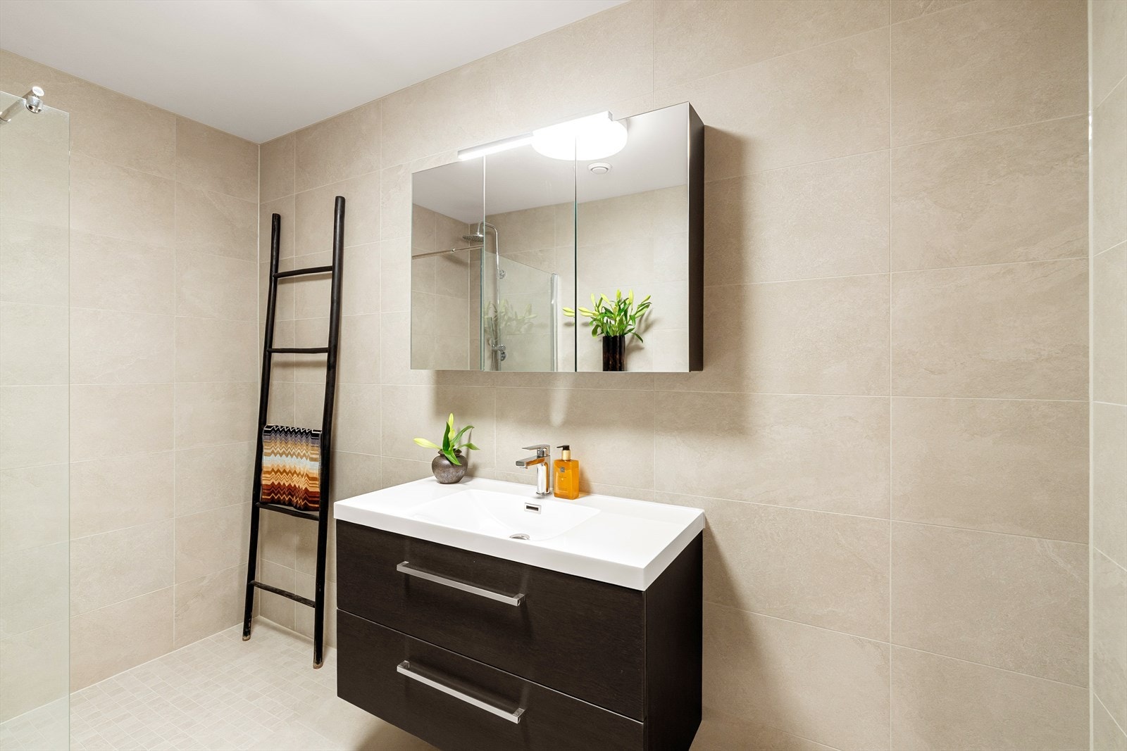 Badet er lekkert med grå fliser, vegghengt toaltt, regndusj og dusjvegg i klart glass. Pen innredning med speilskap.
Oppgradert i 2019. Galleribilde