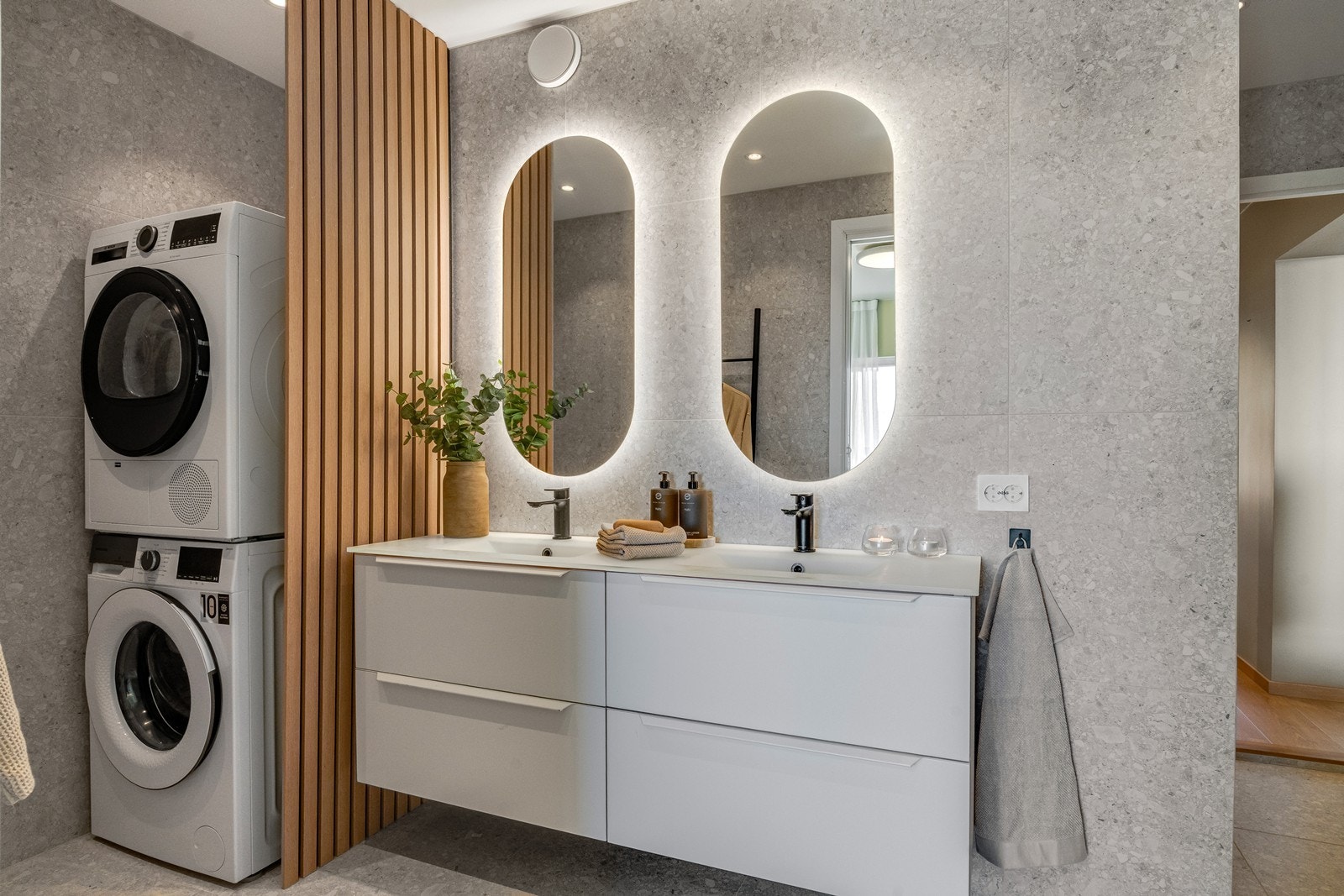 Det er innredet med toalett, servant og dusj, og har en praktisk løsning med opplegg for vaskemaskin og tørketrommel bak en stilren spilevegg. Galleribilde