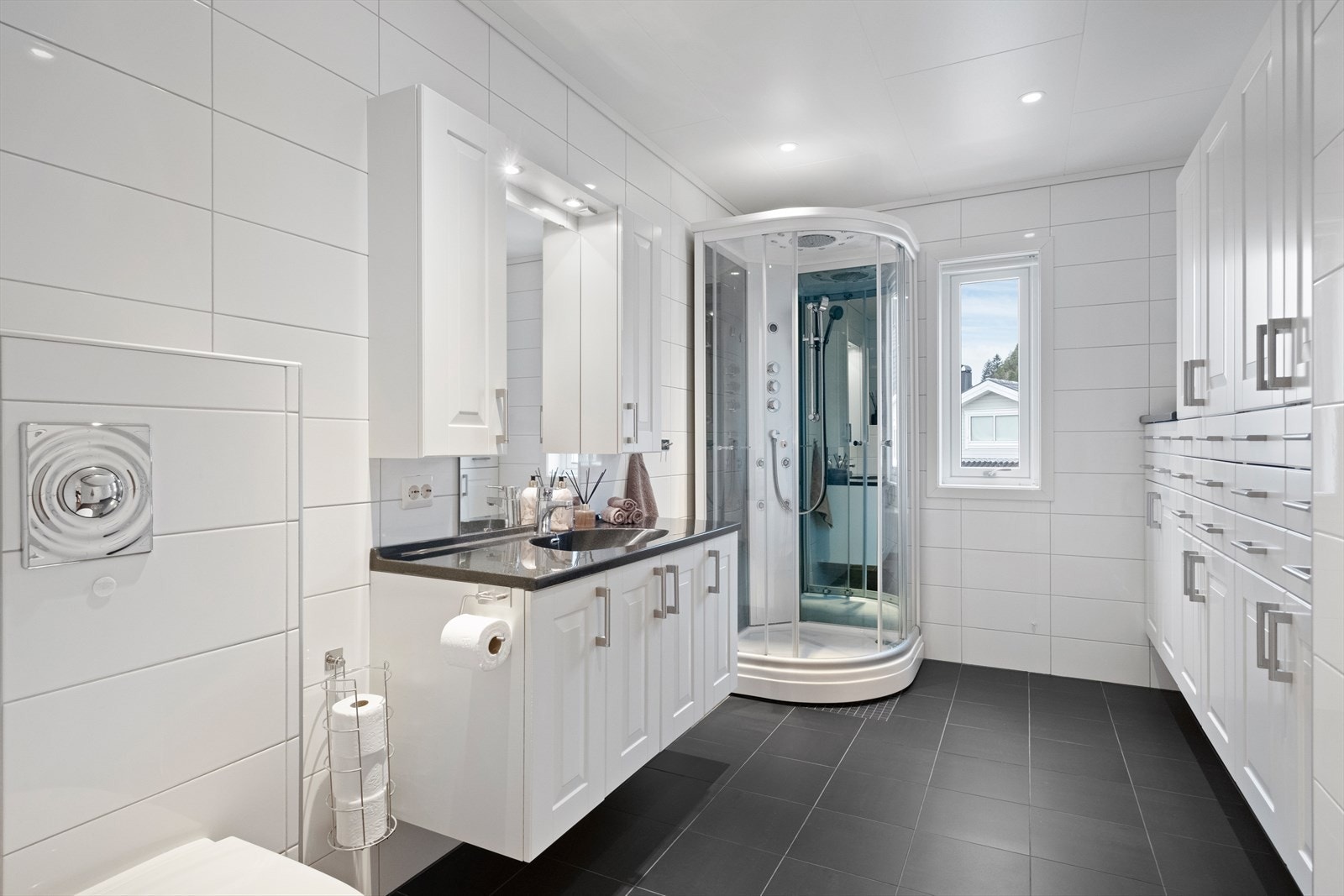 Pent bad med vegghengt toalett og dusjkabinett. Galleribilde