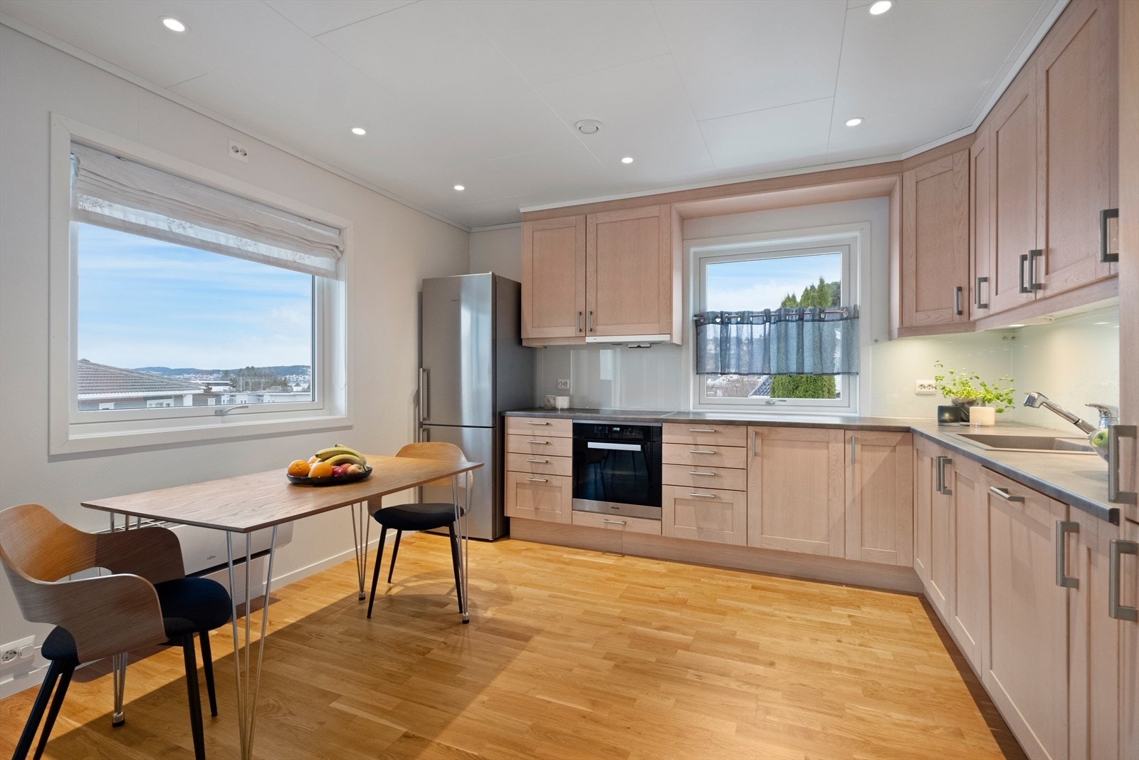 Pent og moderne kjøkken med integrert komfyr, platetopp og oppvaskmaskin. Galleribilde