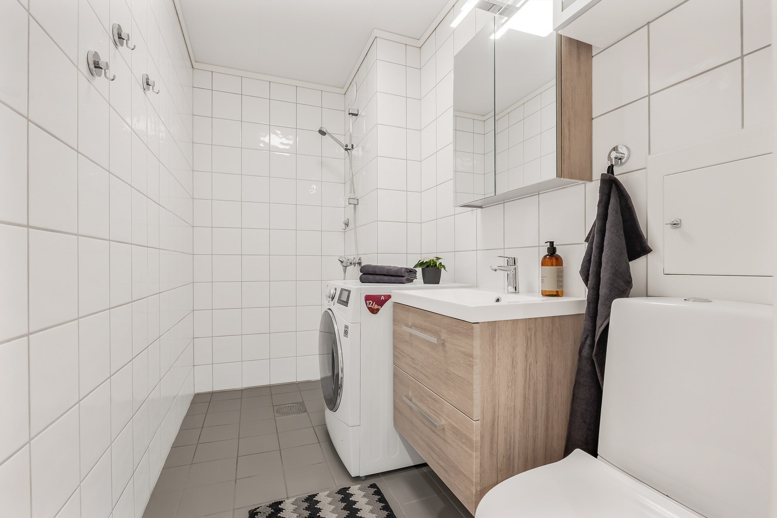 Bad fra byggeår. Flislagt gulv med elektrisk gulvvarme og flislagte vegger. Innredet med servant med speilskap og overlys. Dusjnisje med dusjforheng og dusjarmatur. Galleribilde