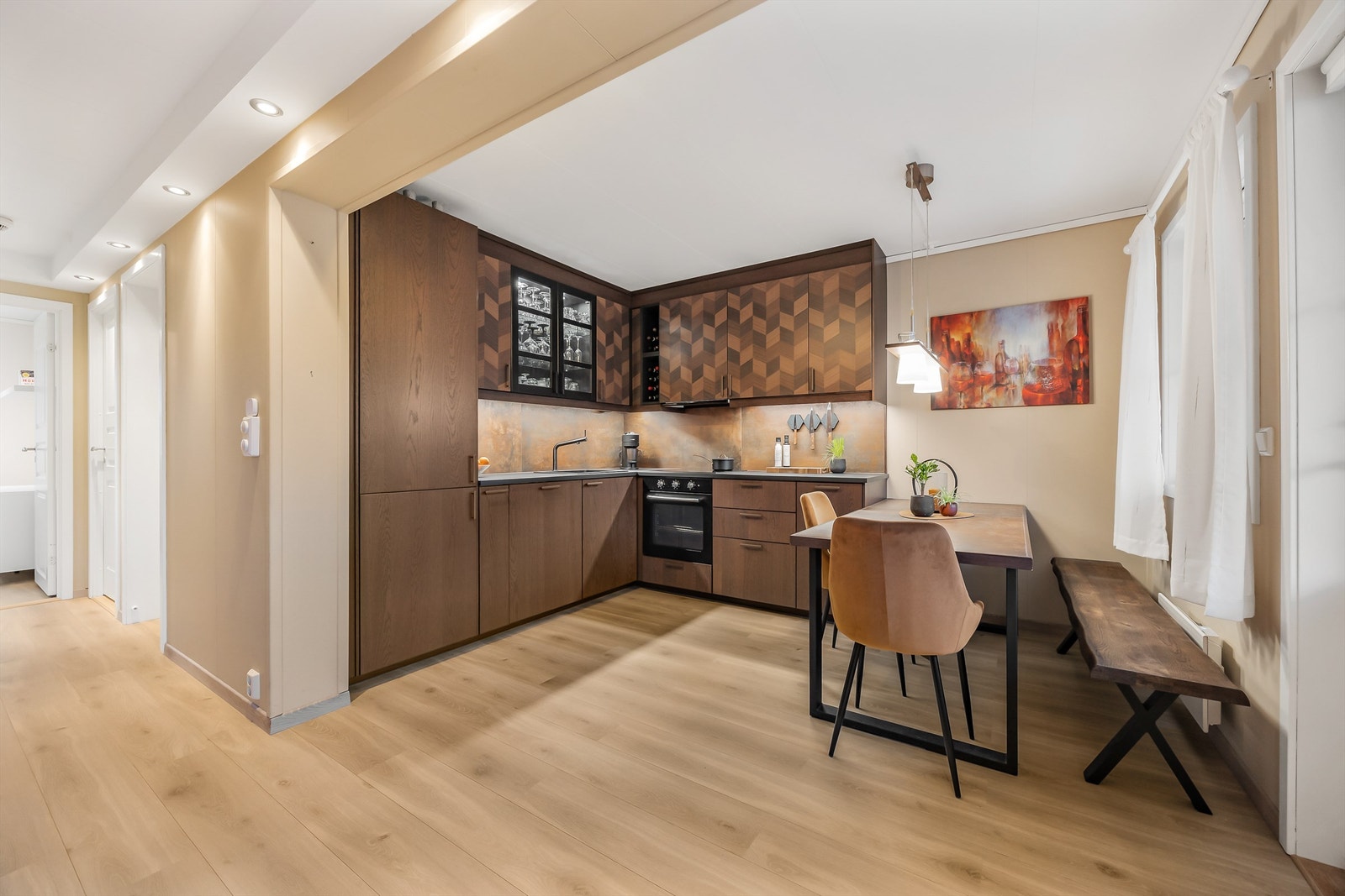 Kjøkken med åpen løsning mot stue som gir en luftig og sosial planløsning. Kjøkkeninnredning med glatte fronter fra 2021 og praktiske laminat benkeplater. Galleribilde