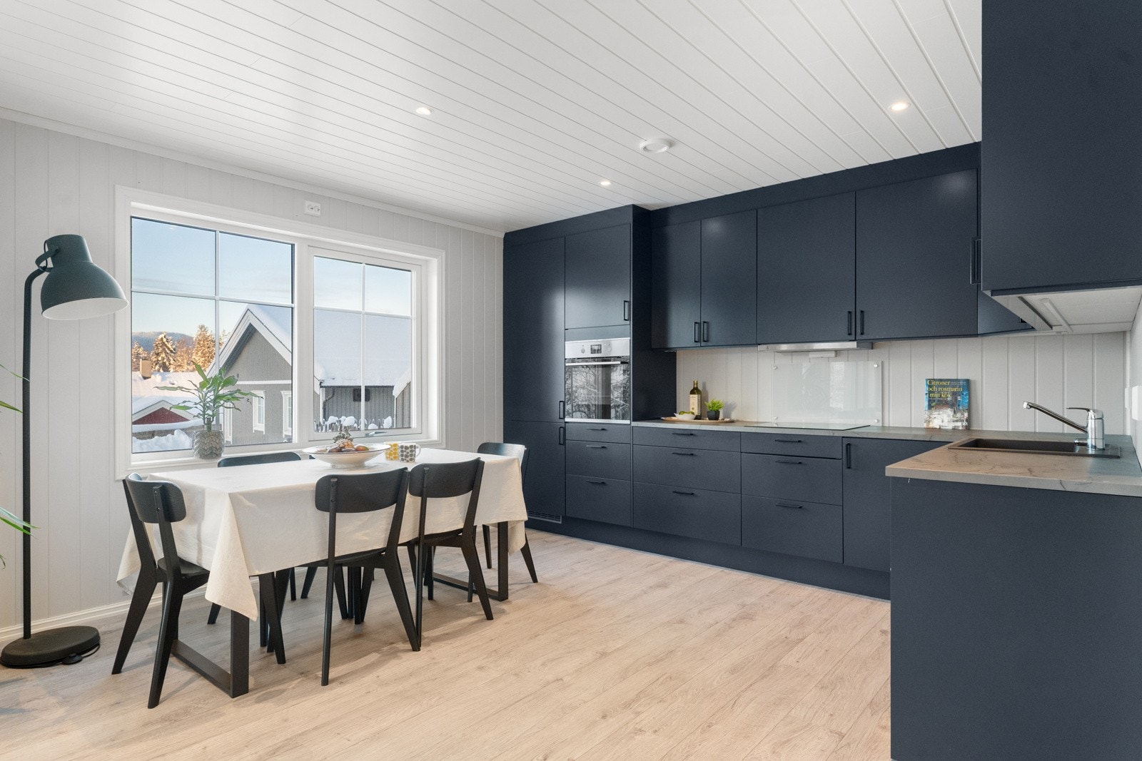 Det stilrene Norema-kjøkkenet med mørke, glatte fronter danner en elegant ramme rundt rommet og er utstyrt med integrerte hvitevarer fra Electrolux. Galleribilde