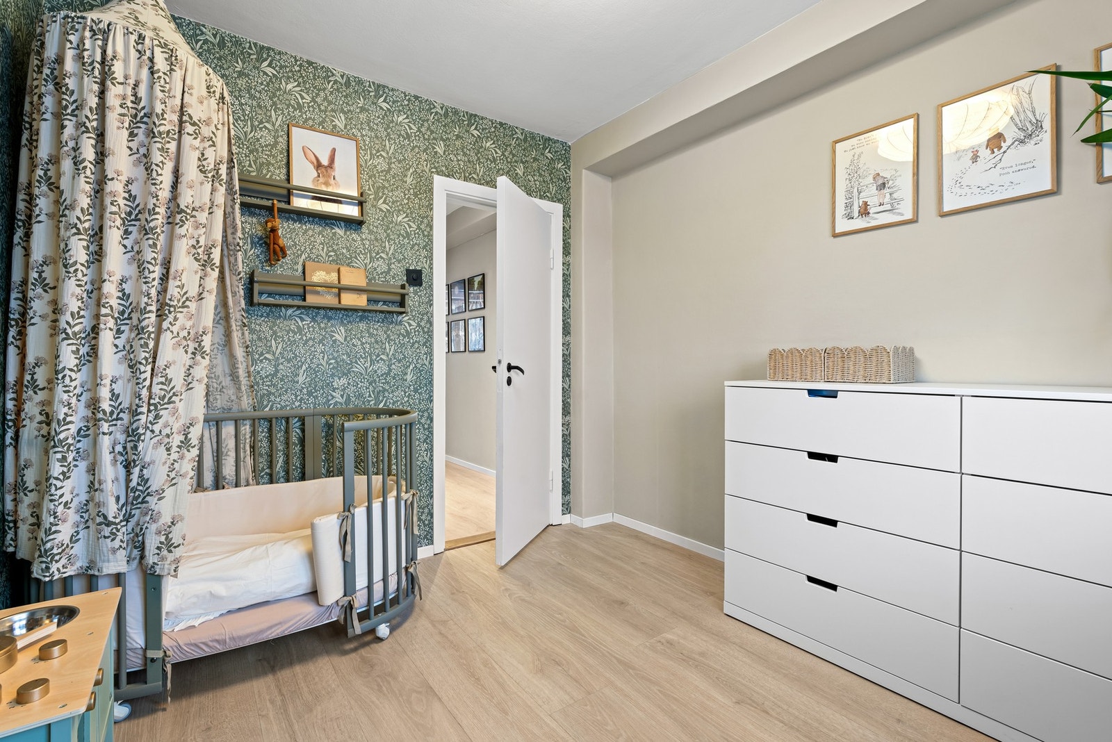 Rommet har lyst laminatgulv og har en stilfull tapet. Galleribilde