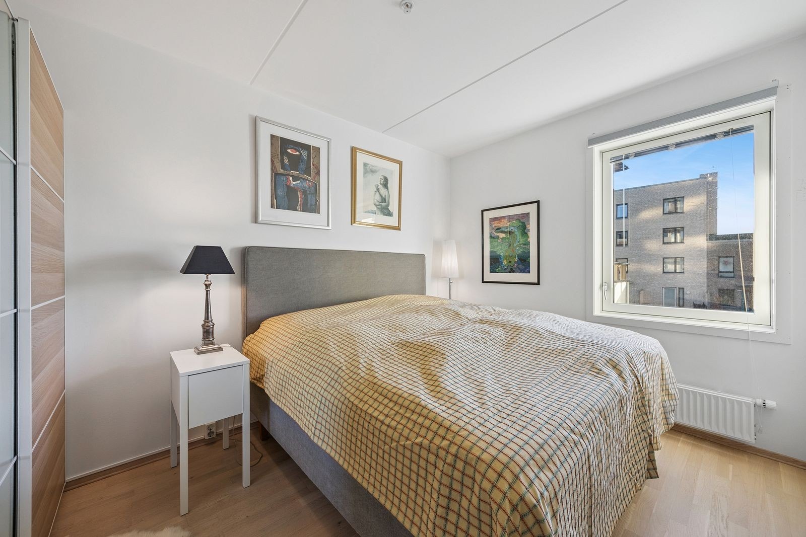 Lyst og romslig soverom med skyvedørsgarderobe Galleribilde