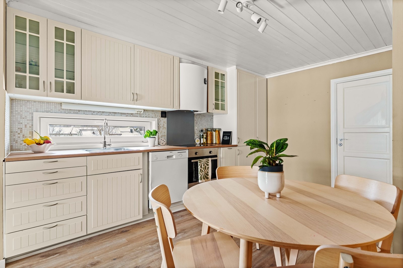 Kjøkkeninnredning med lyse fronter og laminat benkeplate. Galleribilde