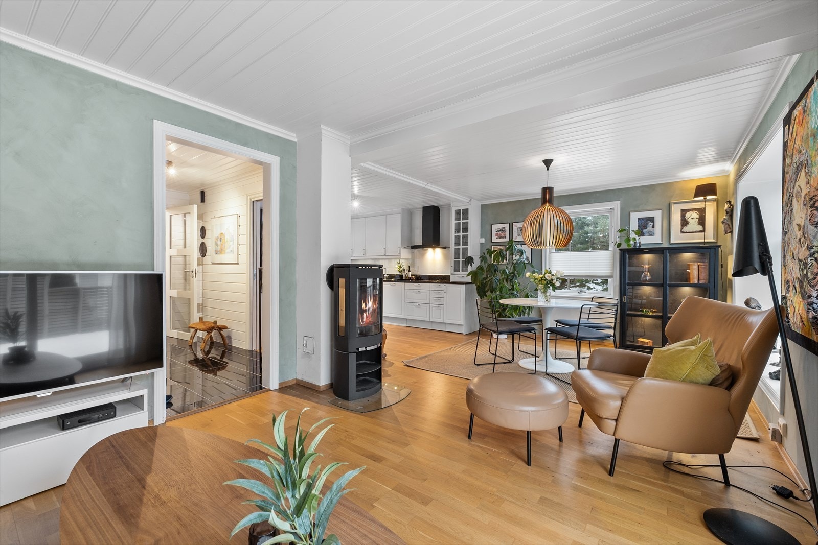 Stuen fremstår som et lunt og harmonisk oppholdsrom, malt i en nydelig dus grønnfarge som skaper en rolig og behagelig atmosfære. Fargevalget gir rommet karakter og varme, samtidig som det oppleves lyst og innbydende. Galleribilde