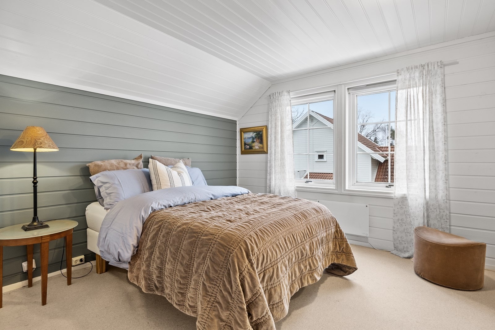 Hovedsoverommet fremstår som et lunt og innbydende rom med panel på veggene. Det myke teppet på gulvet bidrar til ekstra komfort og en behagelig start på dagen, samtidig som det forsterker den rolige og hjemmekoselige følelsen i rommet. Galleribilde